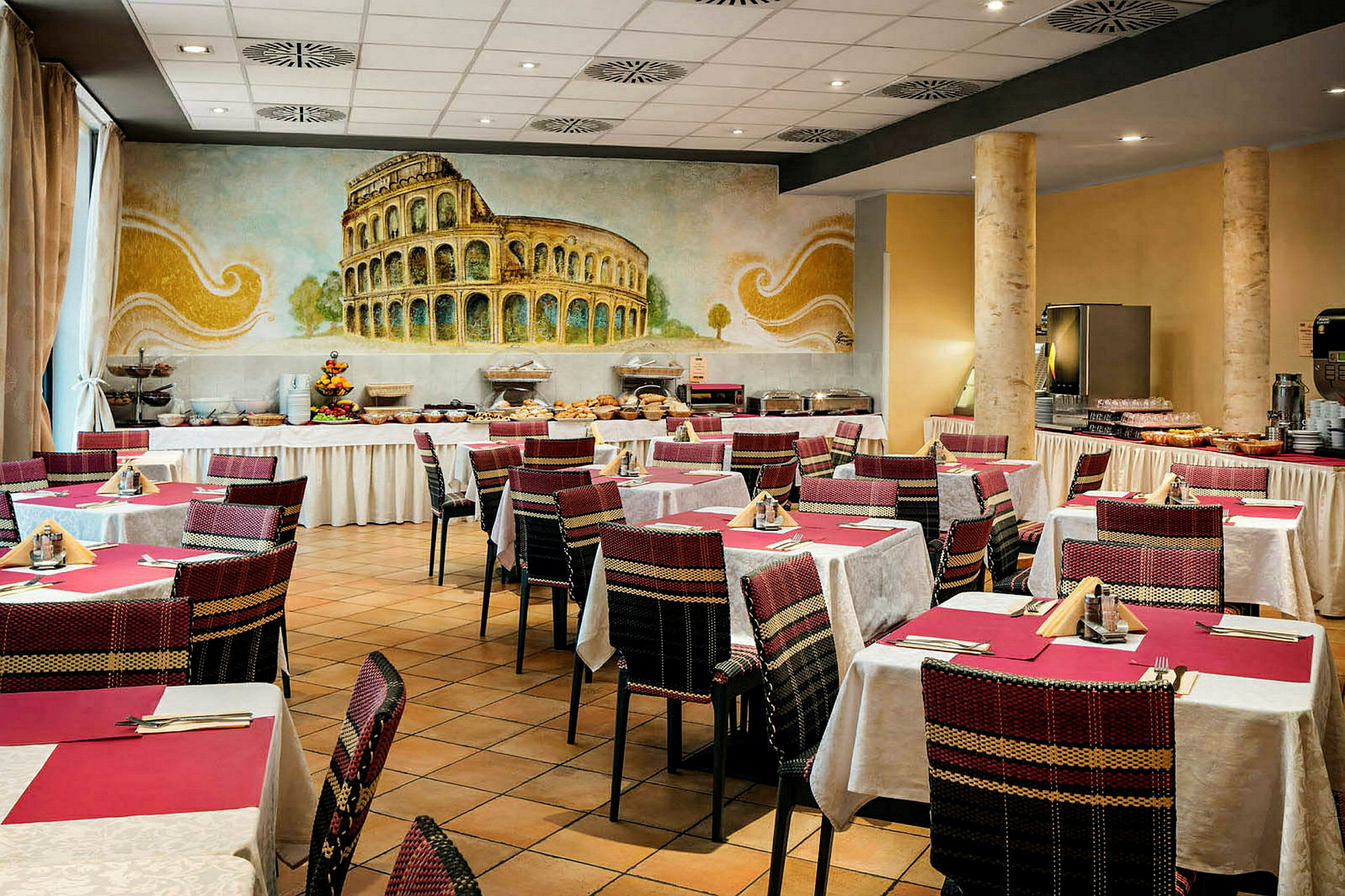 Et restaurantområde med dekkede bord og stoler, med et veggmaleri som viser Colosseum i bakgrunnen. (AI-generert tekst)