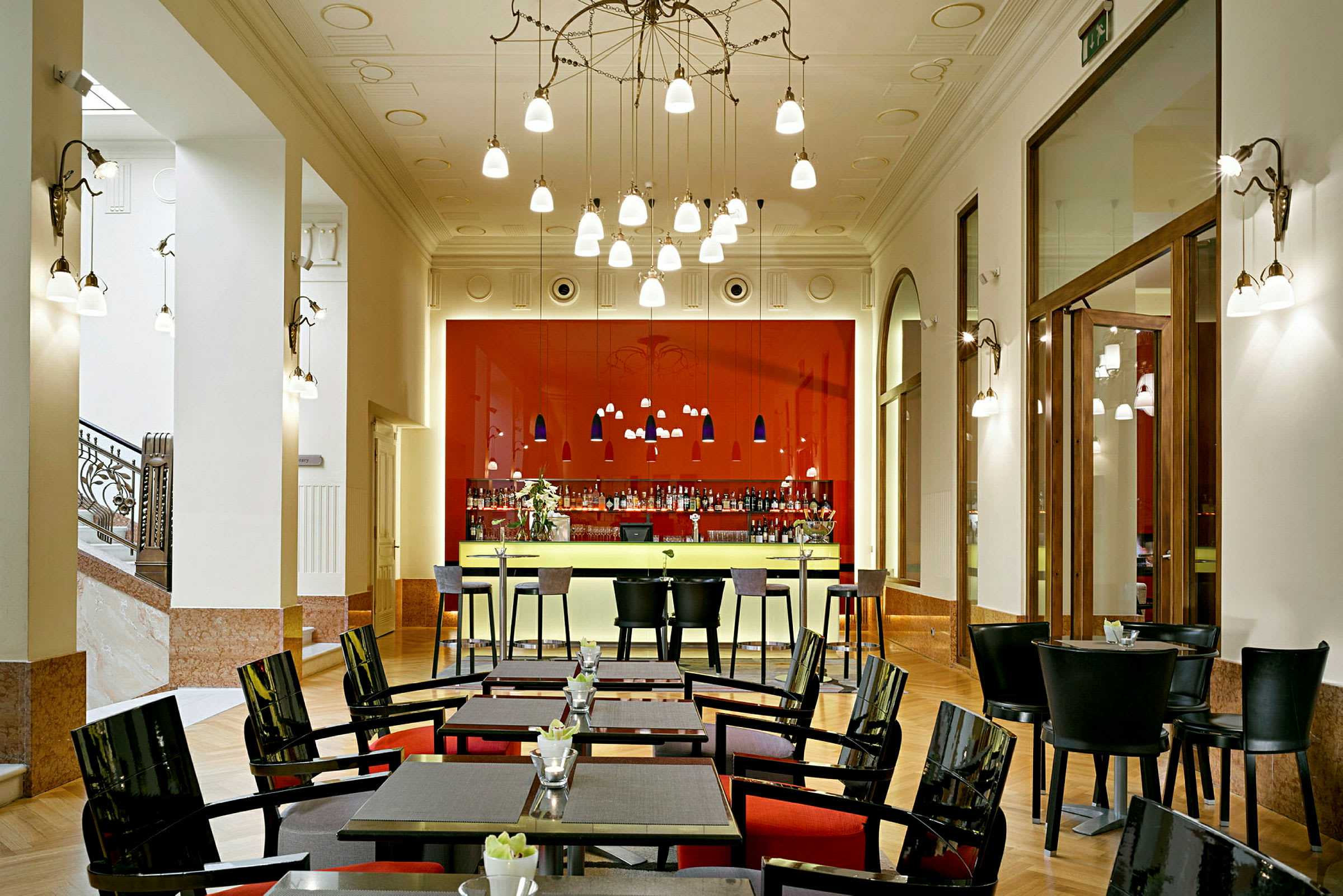 Bilde av en elegant bar og restaurant med røde detaljer, moderne møbler og dekorative lamper. (AI-generert tekst)