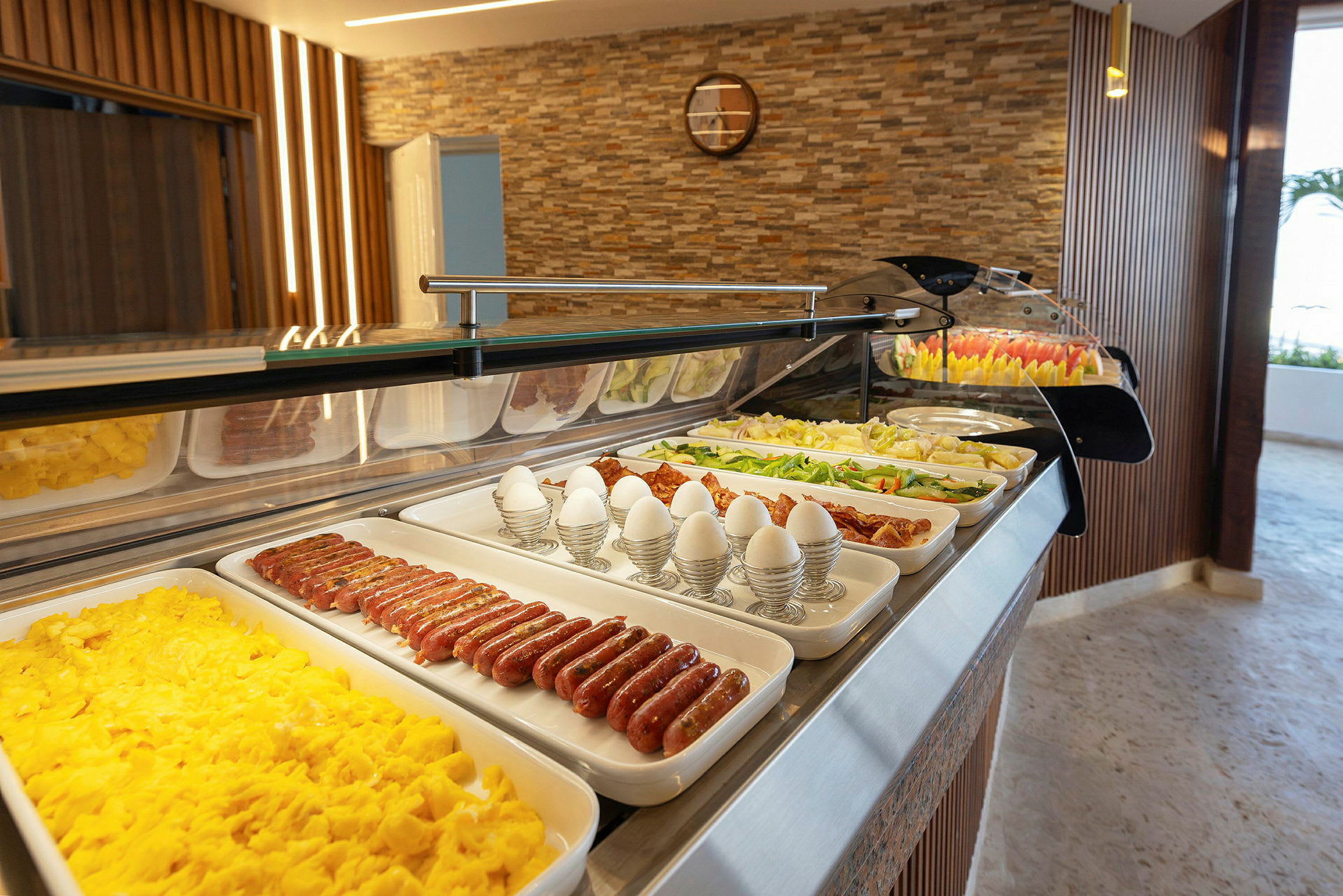 En buffet med frokostmat som egg, pølser og grønnsaker. (AI-generert tekst)