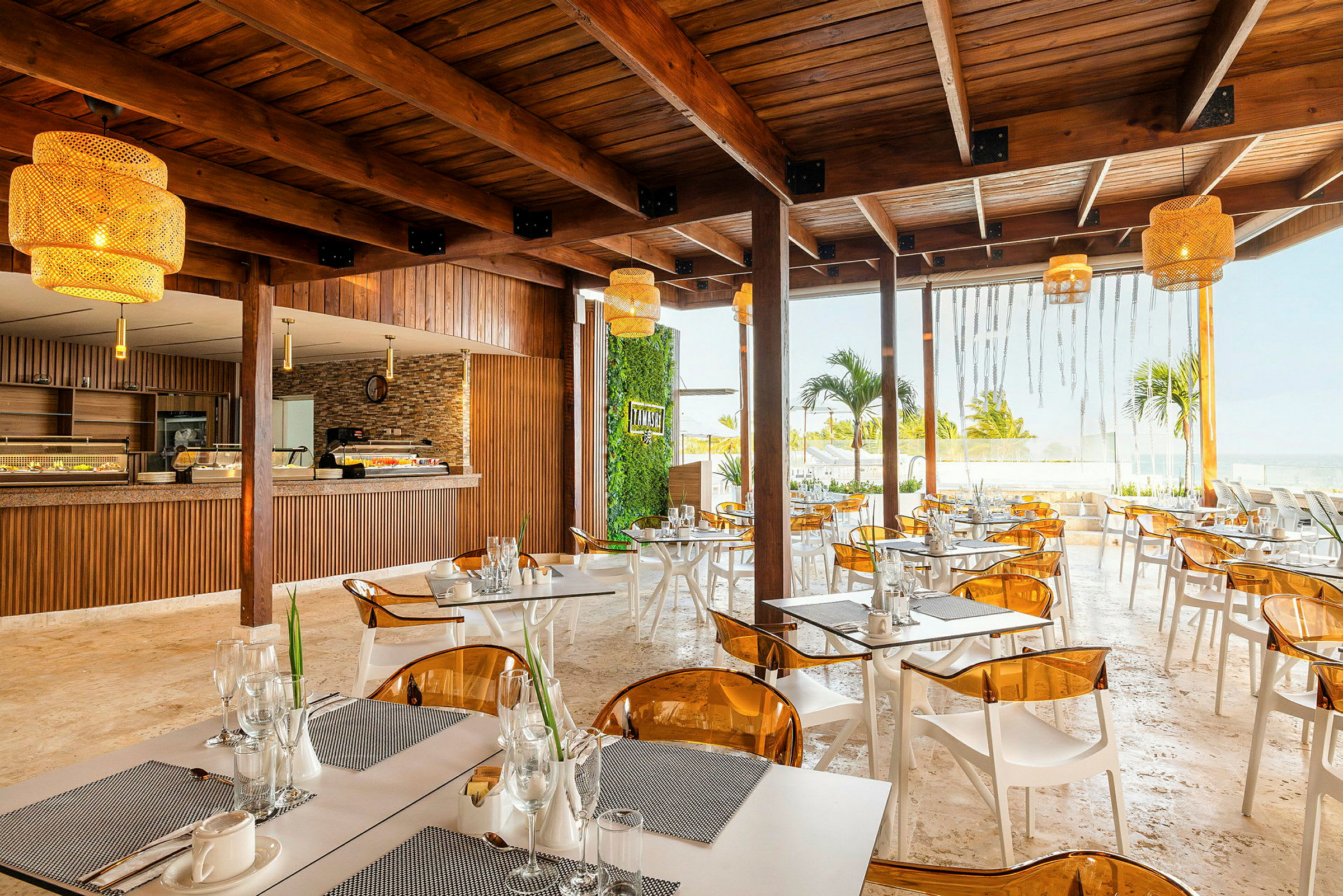 En moderne restaurant med tremøbler, gule lamper og utsikt over havet. (AI-generert tekst)