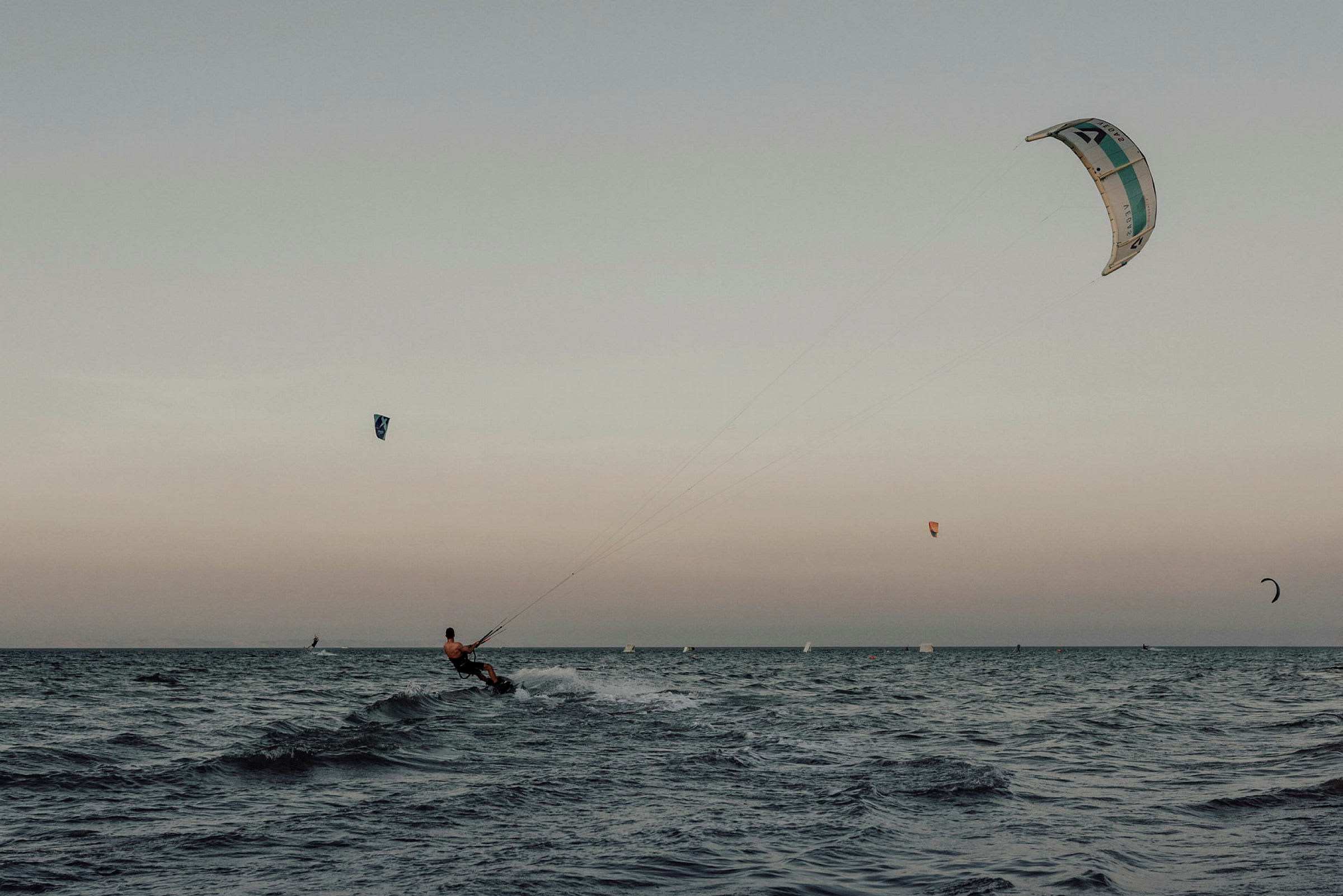 En person driver med kitesurfing på havet. (AI-generert tekst)