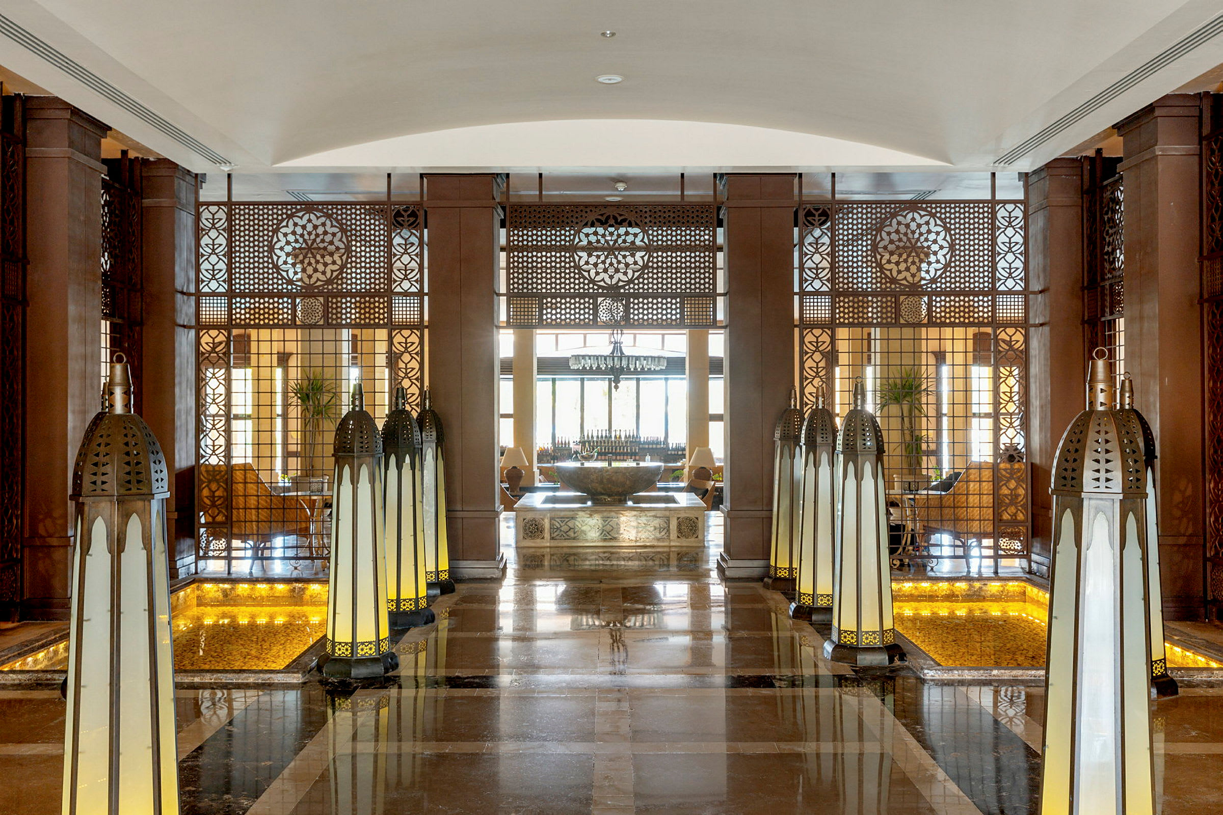 Interiør av en elegant hotellobby med lampedekorasjoner og et sentralt bord. (AI-generert tekst)