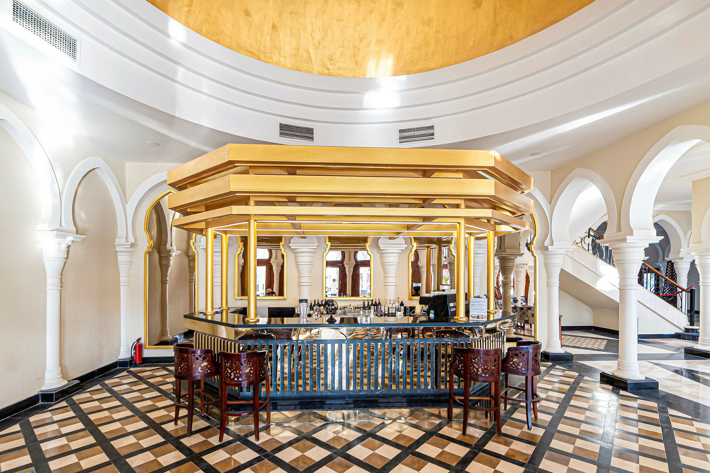 En elegant hotellbar med gulldetaljer og marmorgulv. (AI-generert tekst)