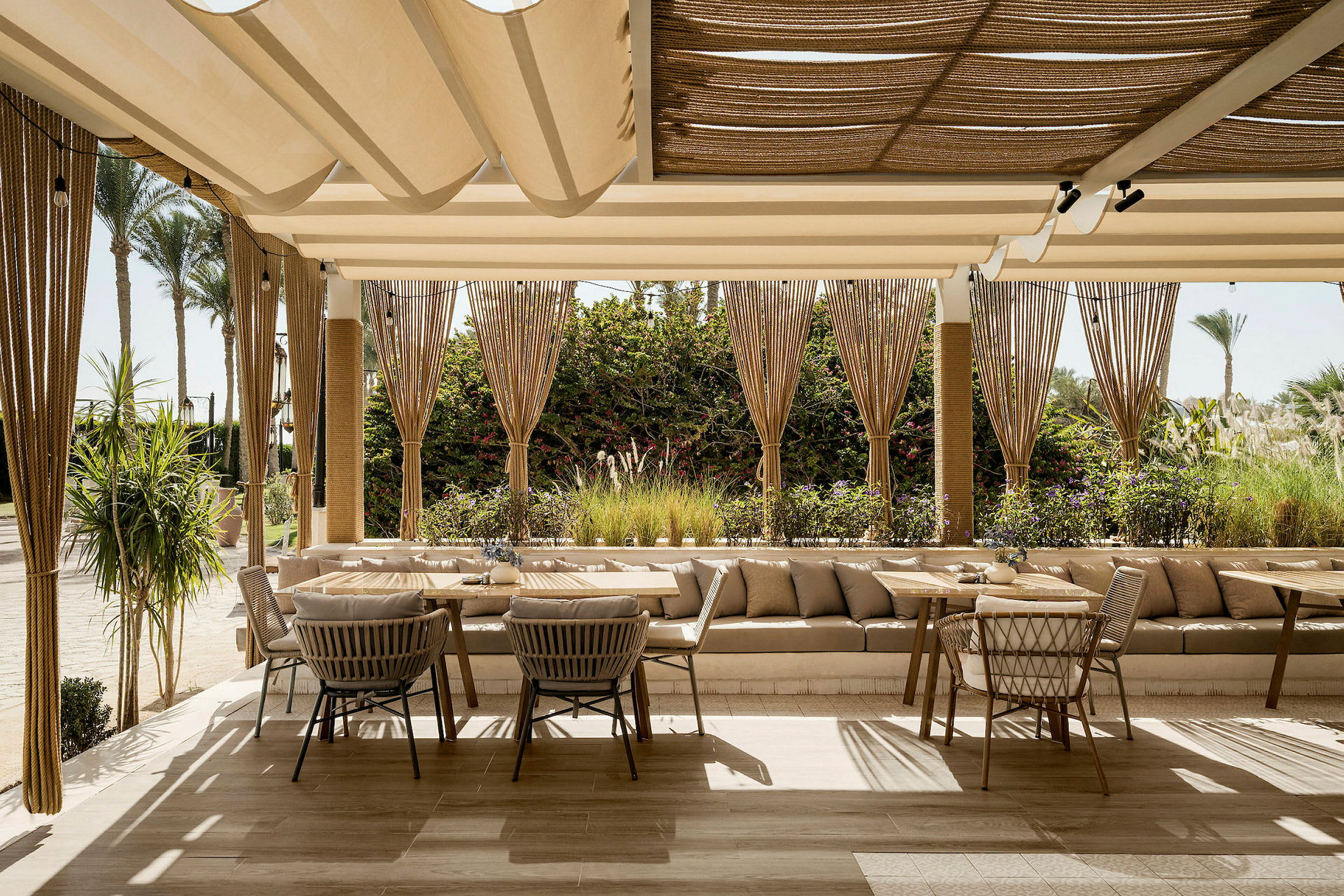 En smakfull restaurantterrasse med komfortable møbler og en vakker utsikt over grøntområder. (AI-generert tekst)