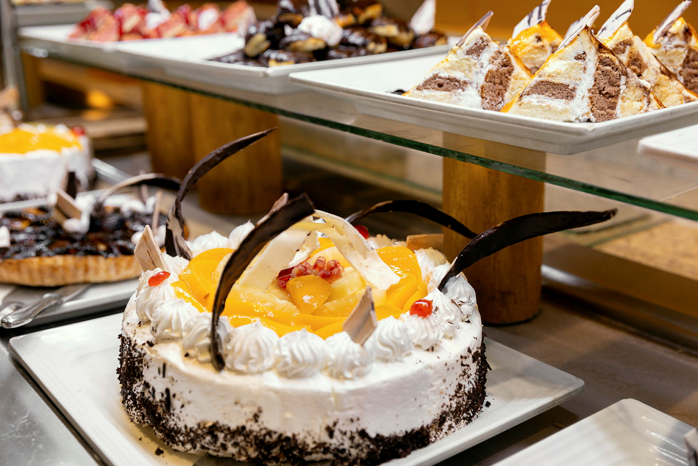 En velsmakende dessertbuffé med en dekorert kake med frukt og sjokolade i fokus. (AI-generert tekst)