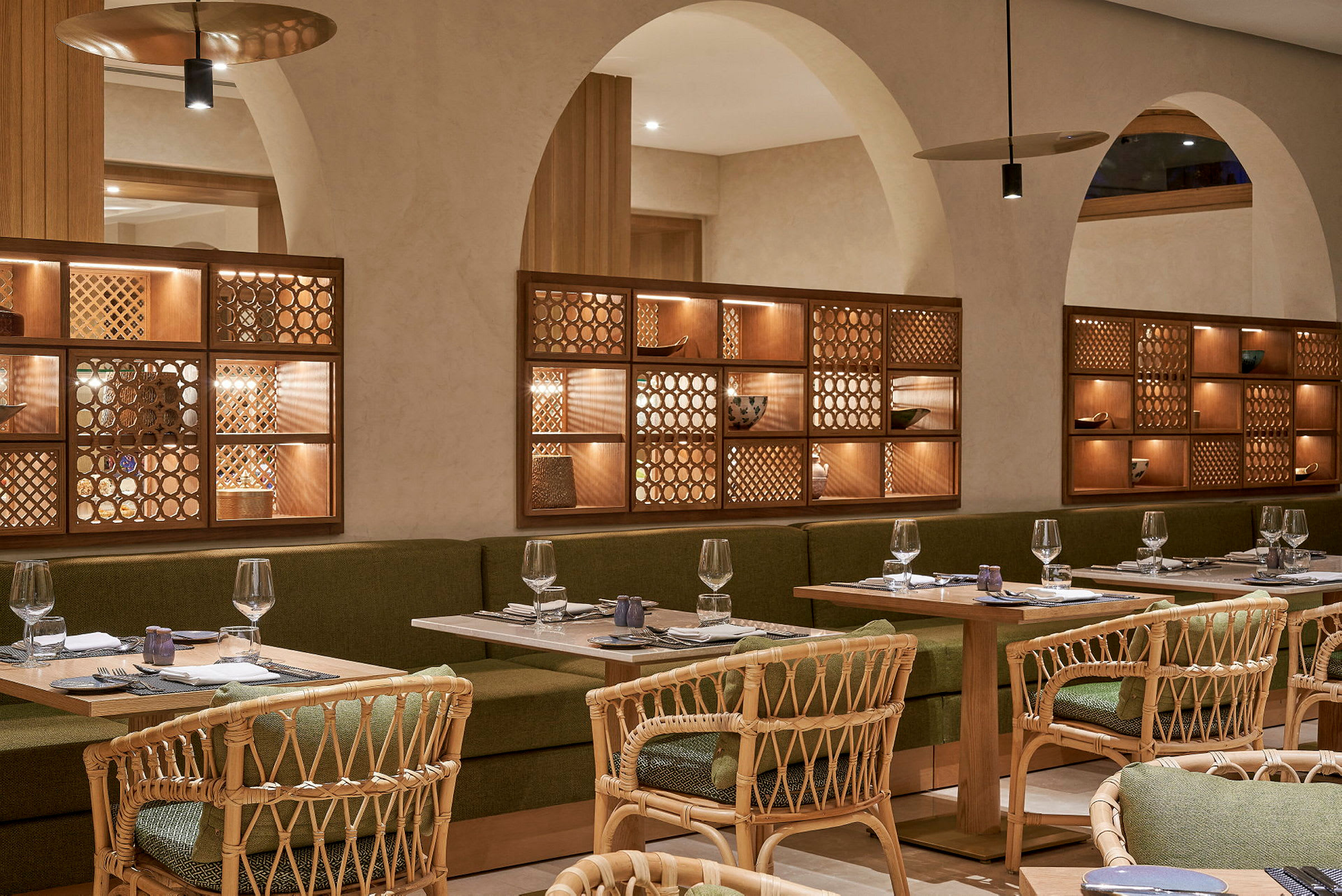 Innendørs bilde av en restaurant med bord, stoler og innredning av tre og grønt stoff. (AI-generert tekst)