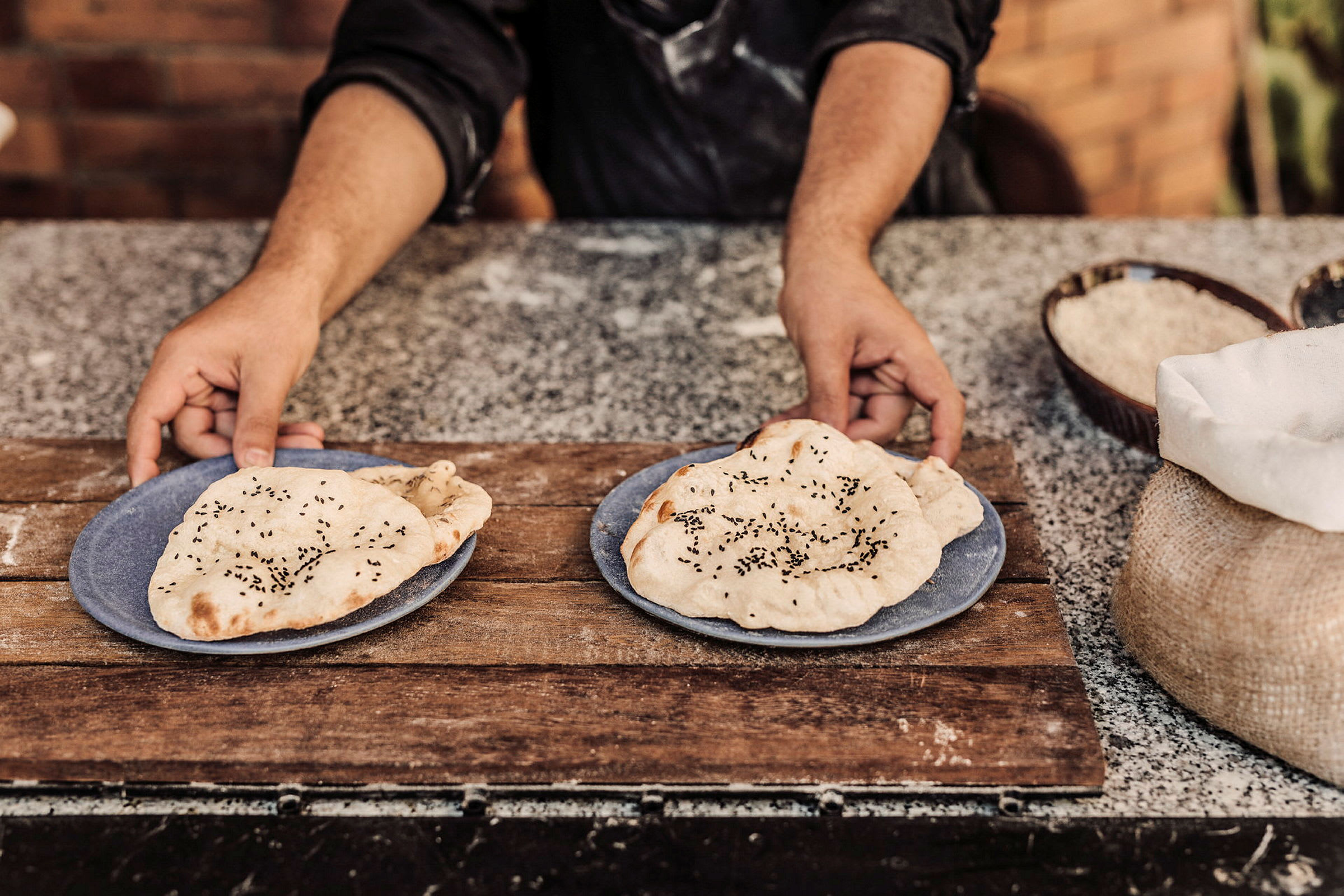 Person som holder tallerkener med nybakte flatbrød. (AI-generert tekst)