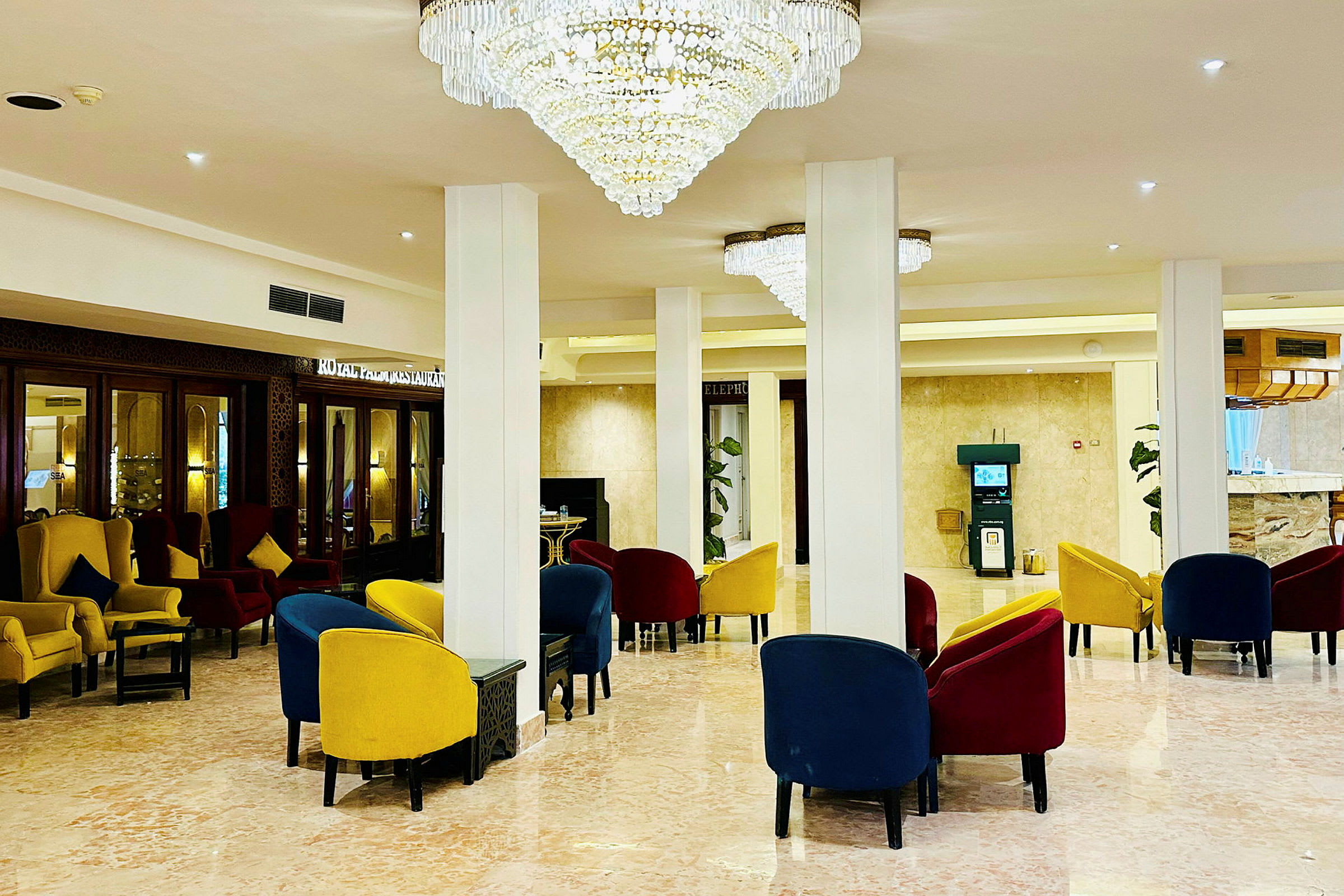 Et elegant hotellobbyområde med fargerike stoler og storslåtte lysekroner. (AI-generert tekst)