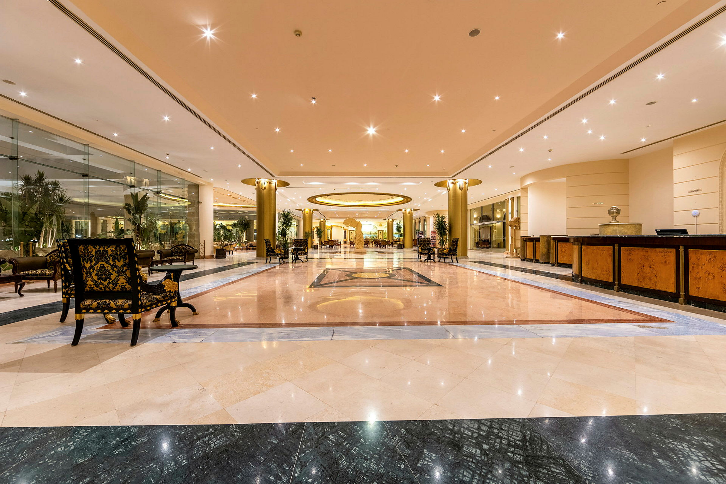 Interiør av en hotellobby med marmorgulv og takbelysning. (AI-generert tekst)
