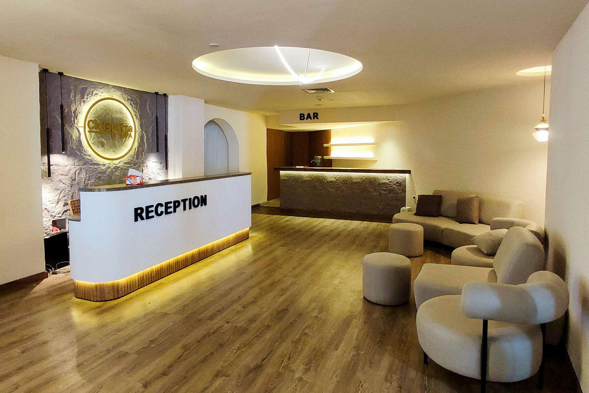 Hotellresepsjon med sittegruppe og bar i bakgrunnen. (AI-generert tekst)