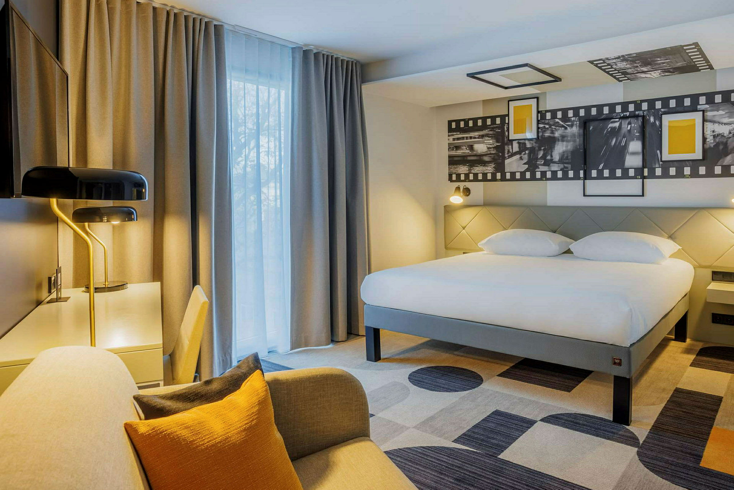 Hotellrom med stor seng, skrivebord og sitteplass. (AI-generert tekst)