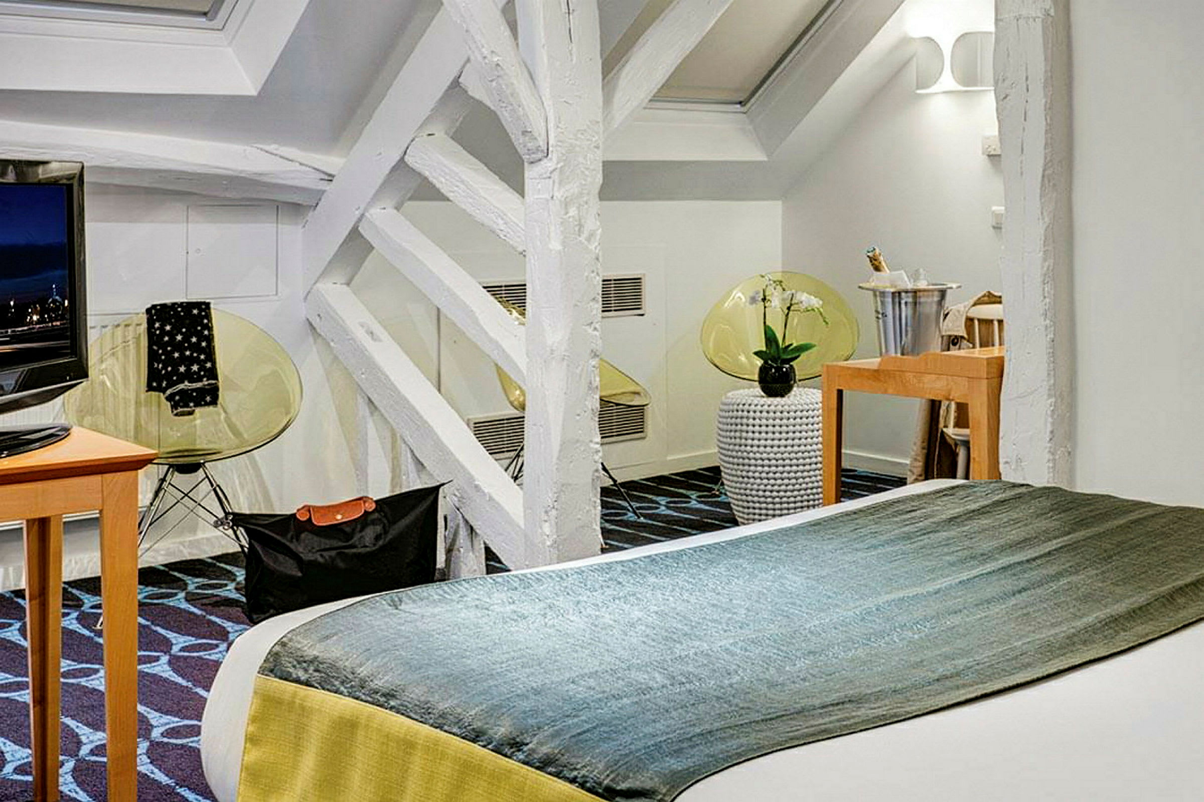 Et moderne hotellrom med dobbeltseng, TV og dekorative detaljer. (AI-generert tekst)