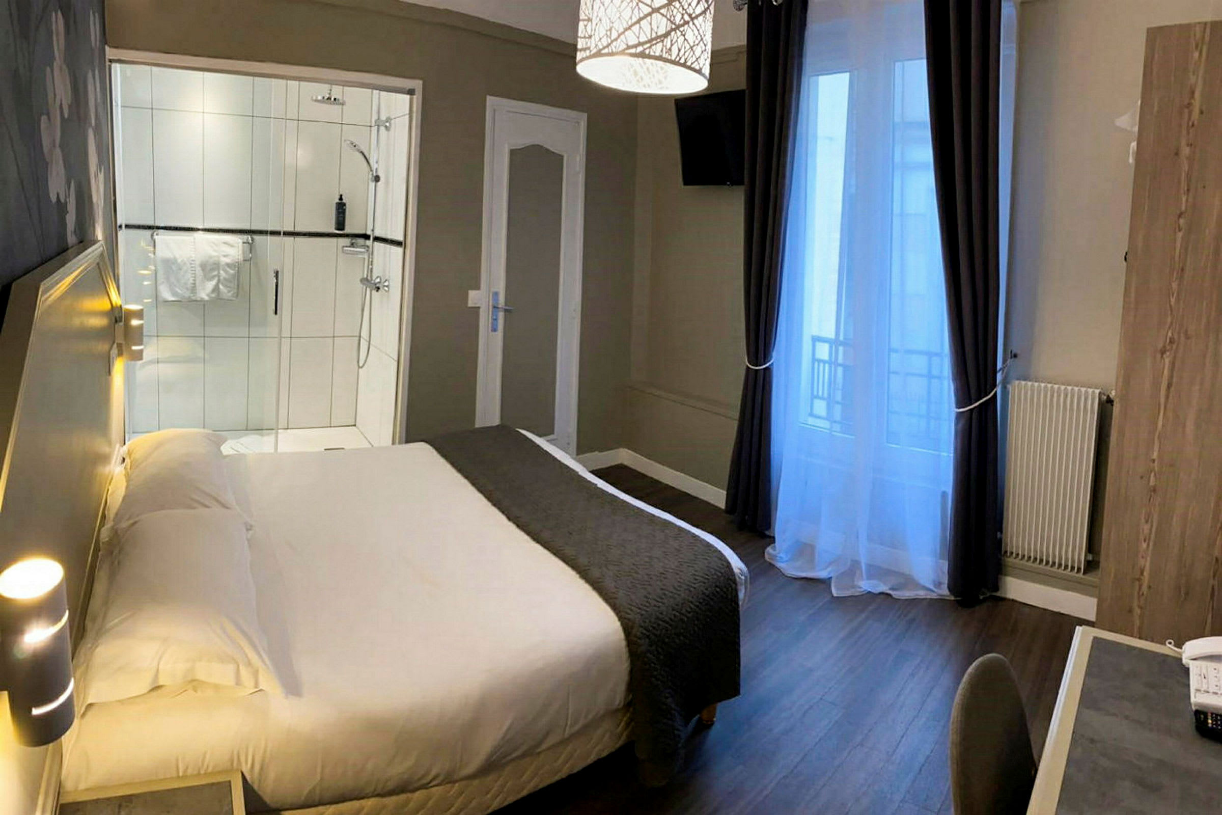 Et hotellrom med en seng, et skrivebord og en dusj. (AI-generert tekst)