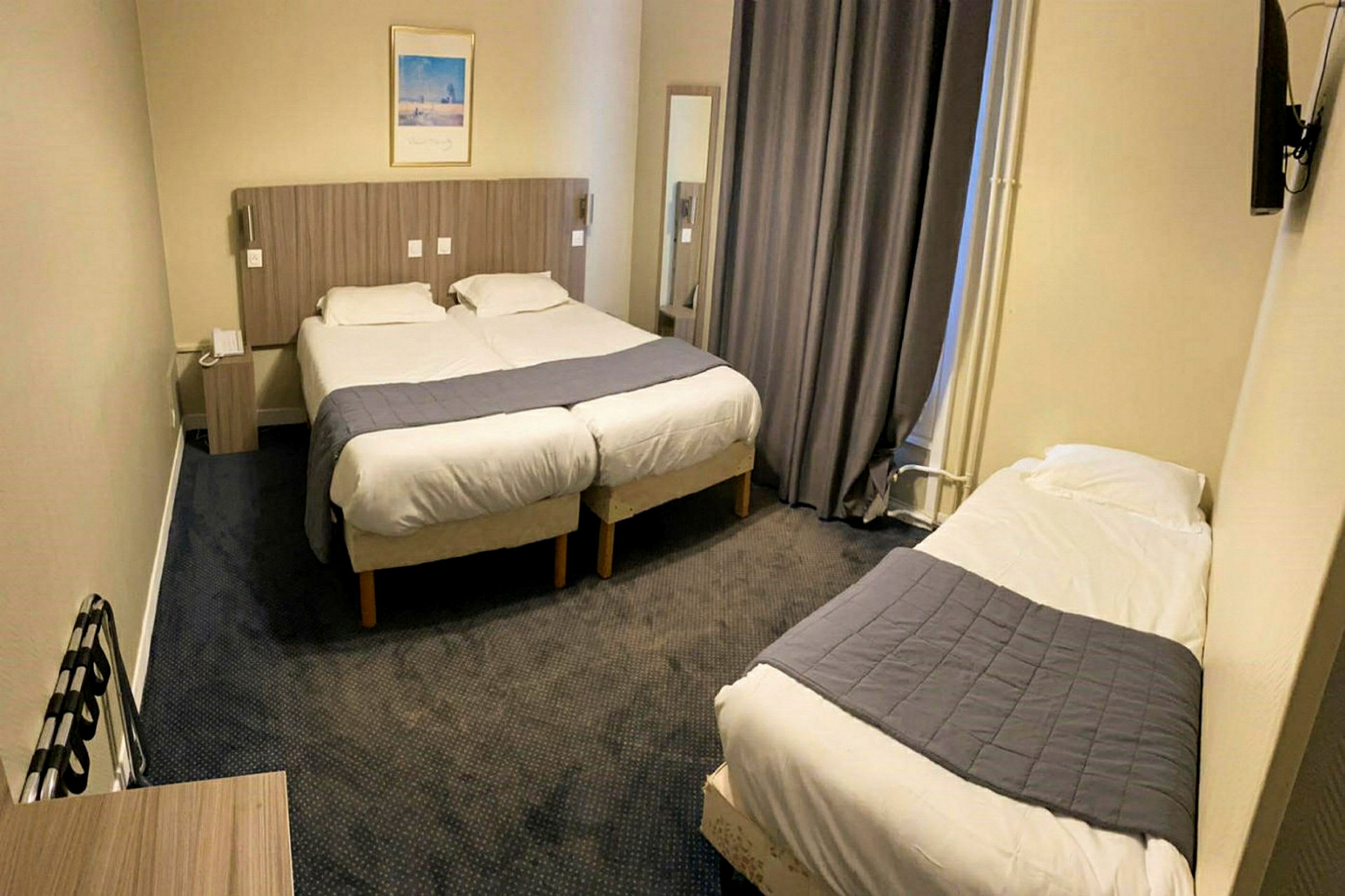 Et hotellrom med to enkeltsenger samlet og en separat enkeltseng. (AI-generert tekst)