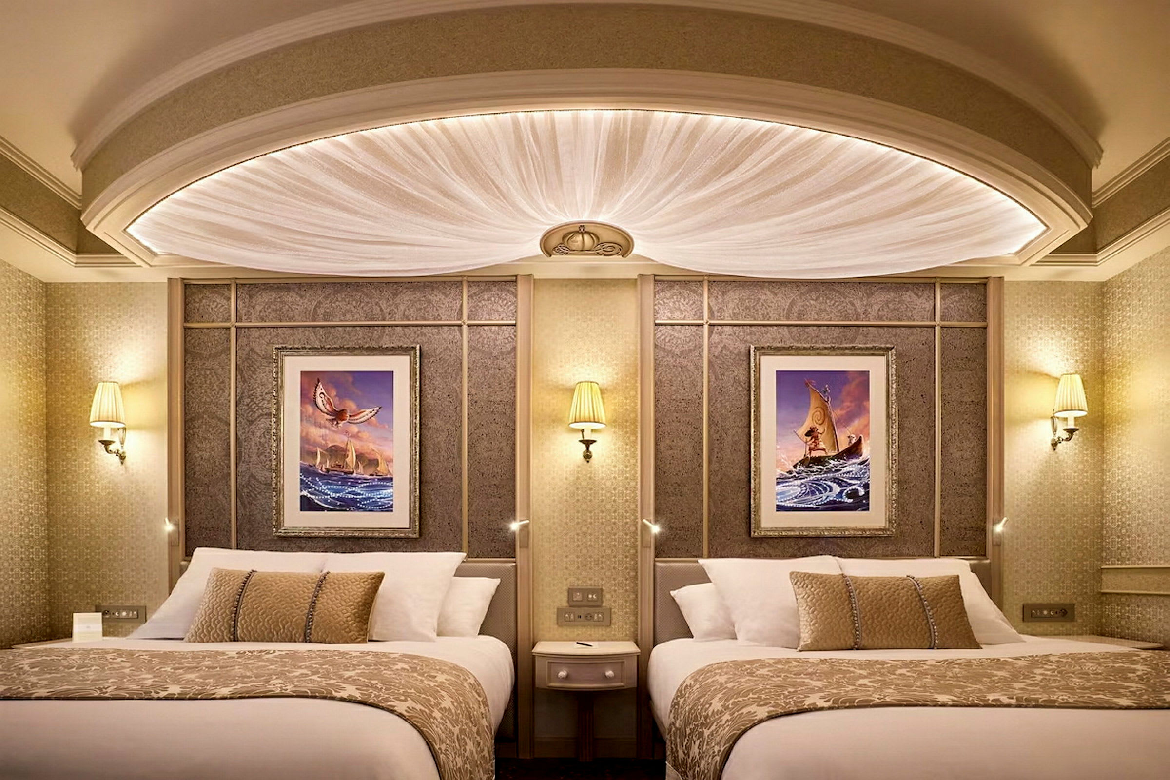 To senger med dekorative puter i et elegant hotellrom med kunstverk på veggen. (AI-generert tekst)
