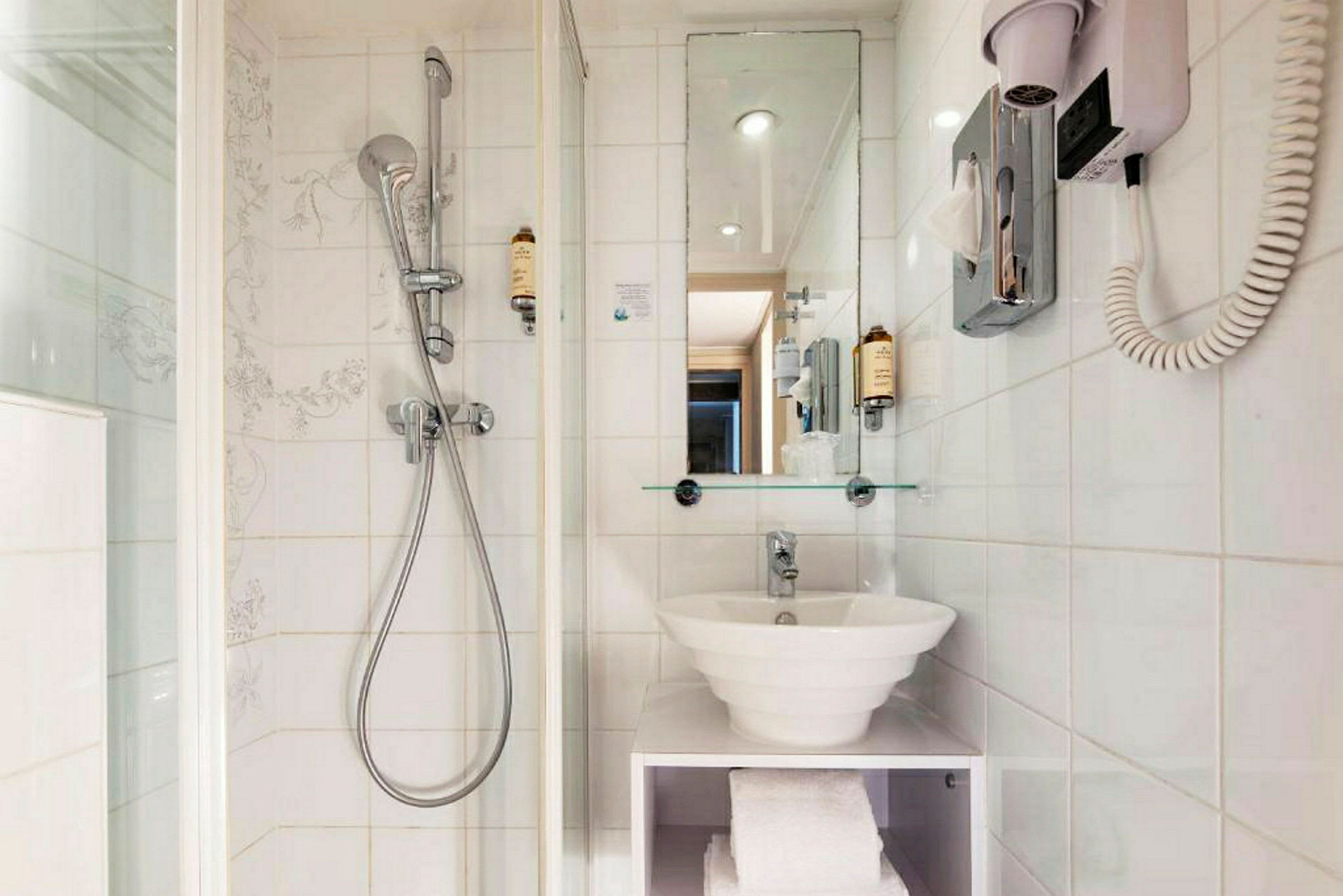 Hotellbad med dusj, speil og servant. (AI-generert tekst)