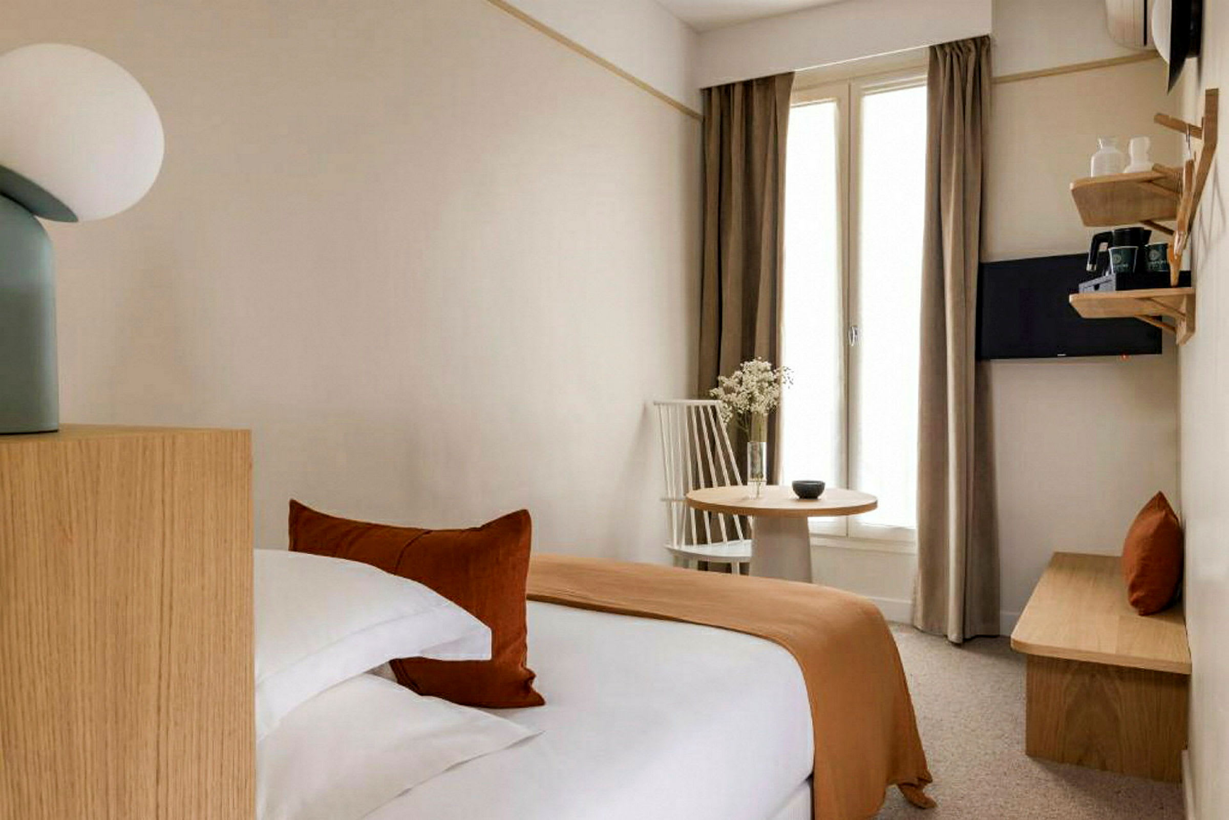 Et hotellrom med en seng, et bord og en stol. (AI-generert tekst)