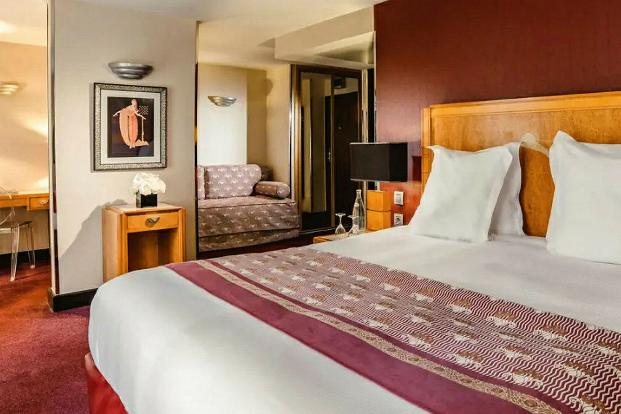 Et hotellrom med dobbeltseng, sofa og skrivebord. (AI-generert tekst)