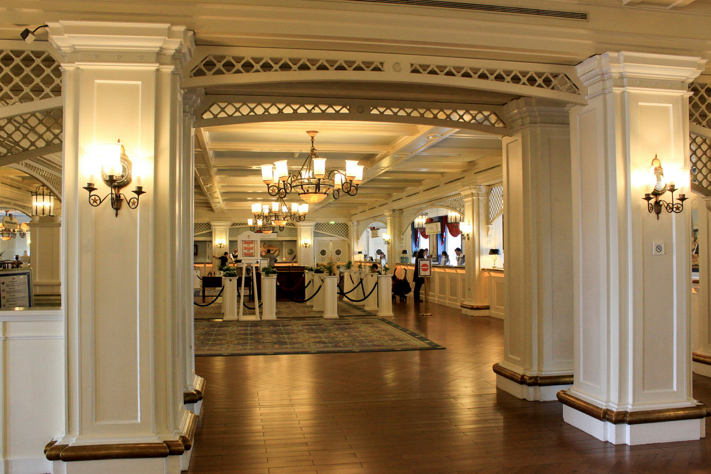 En elegant hotellobby med hvite søyler, lysekroner og resepsjonen. (AI-generert tekst)