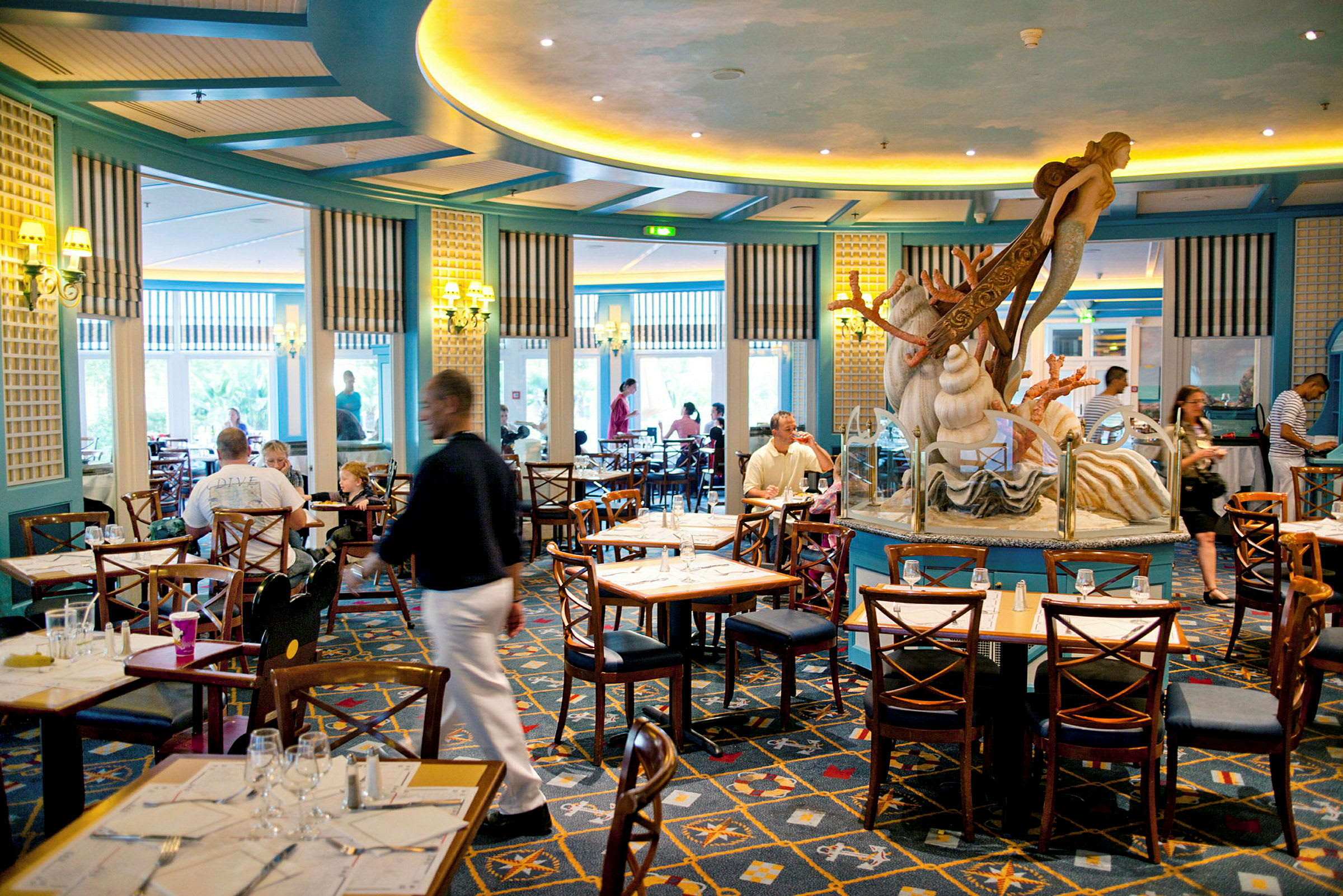 En restaurant med sitteplasser og en dekorasjon i form av en havfigur i midten. (AI-generert tekst)