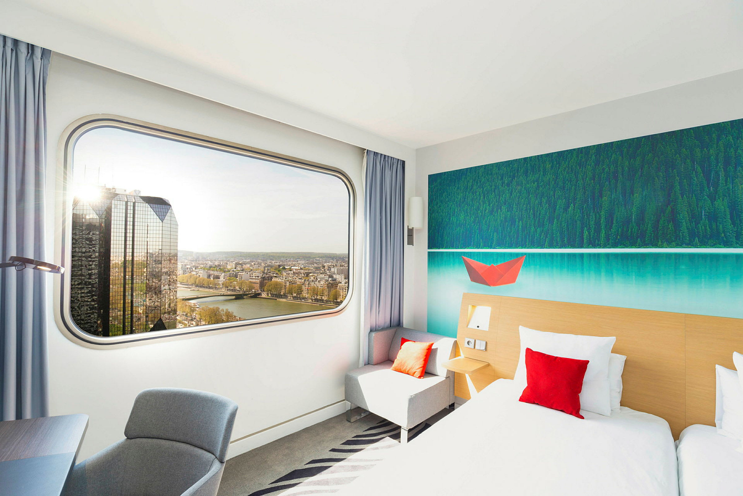 Moderne hotellrom med stort vindu og utsikt over elven. (AI-generert tekst)