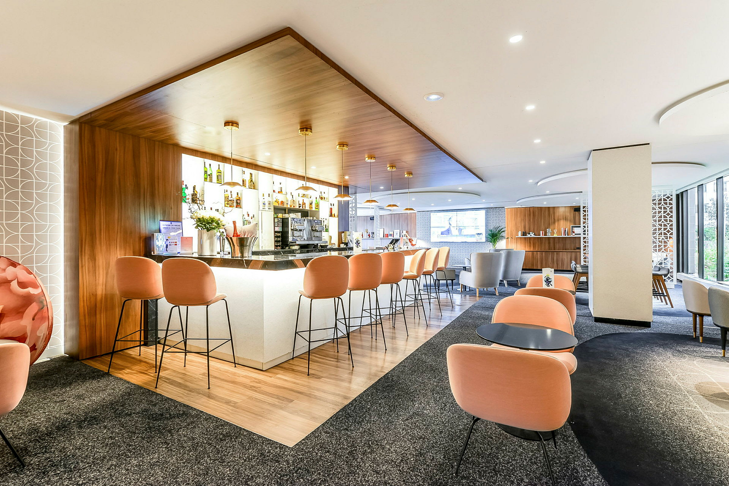 En moderne hotellbar med oransje stoler og en stilren design. (AI-generert tekst)