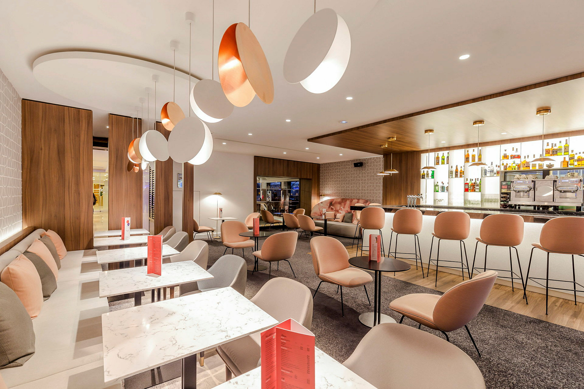 Bilde av en moderne lounge med komfortable sitteplasser, marmorbord og en elegant bardisk. (AI-generert tekst)