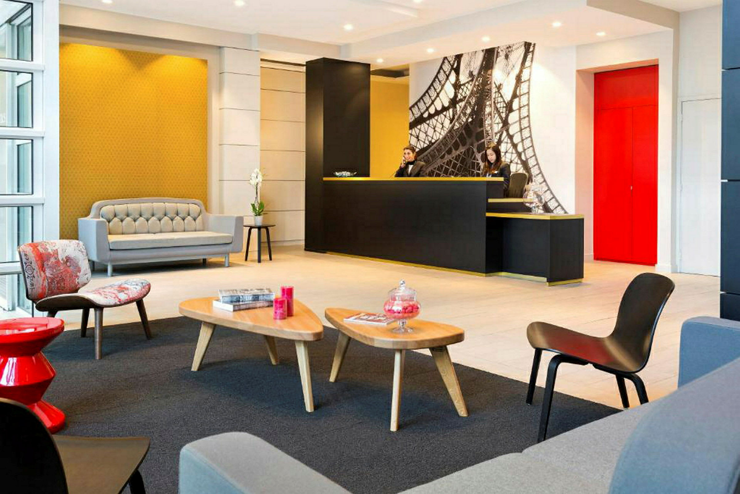 Et moderne hotellresepsjonsområde med lys innredning, sittegruppe og en resepsjonsdisk. (AI-generert tekst)