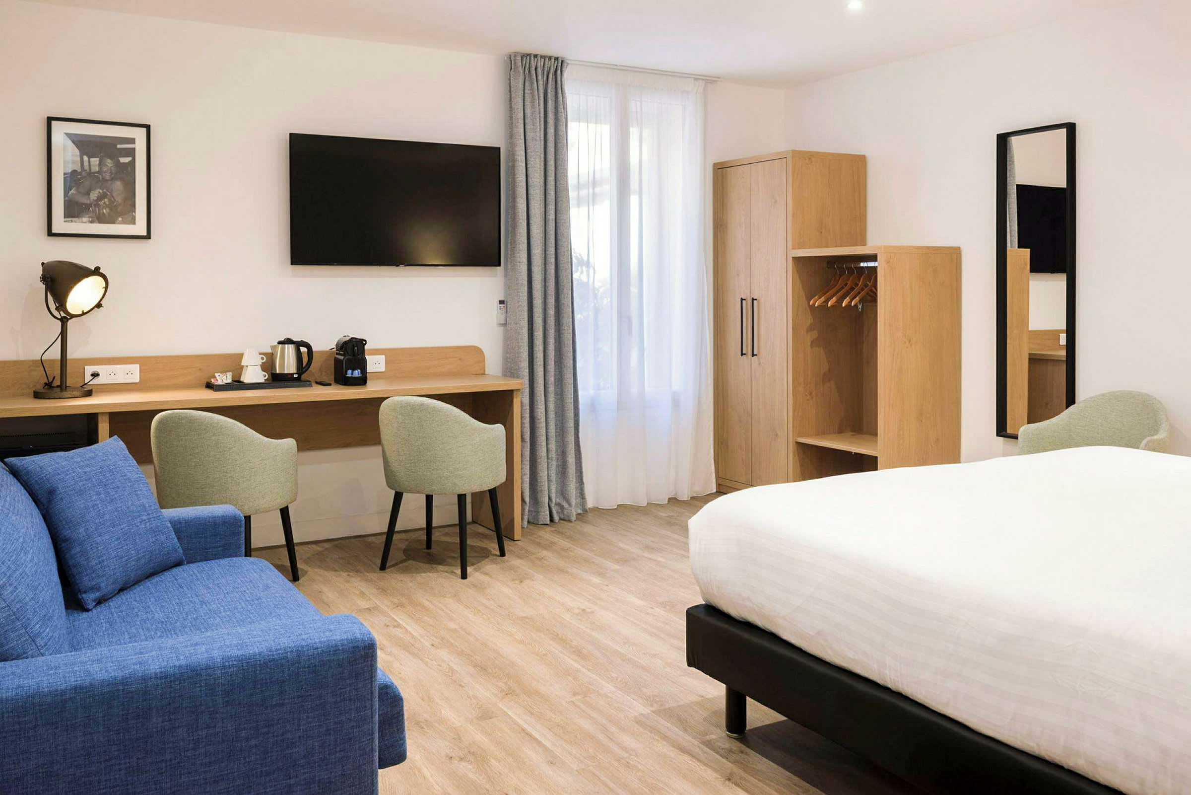Hotellrom med dobbeltseng, sittemøbler, arbeidsbord og garderobe. (AI-generert tekst)