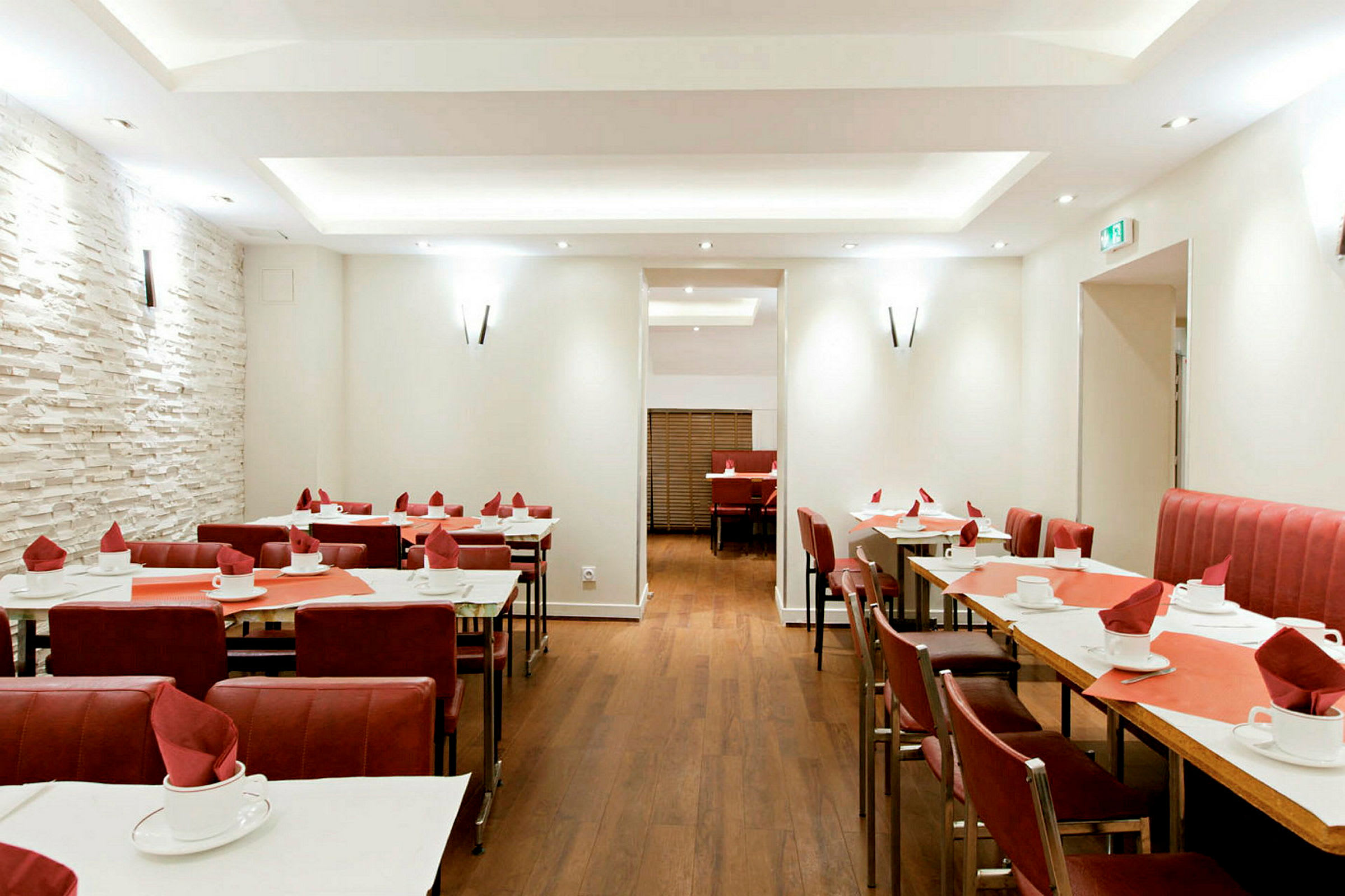Restaurant med dekkede bord og røde stoler. (AI-generert tekst)