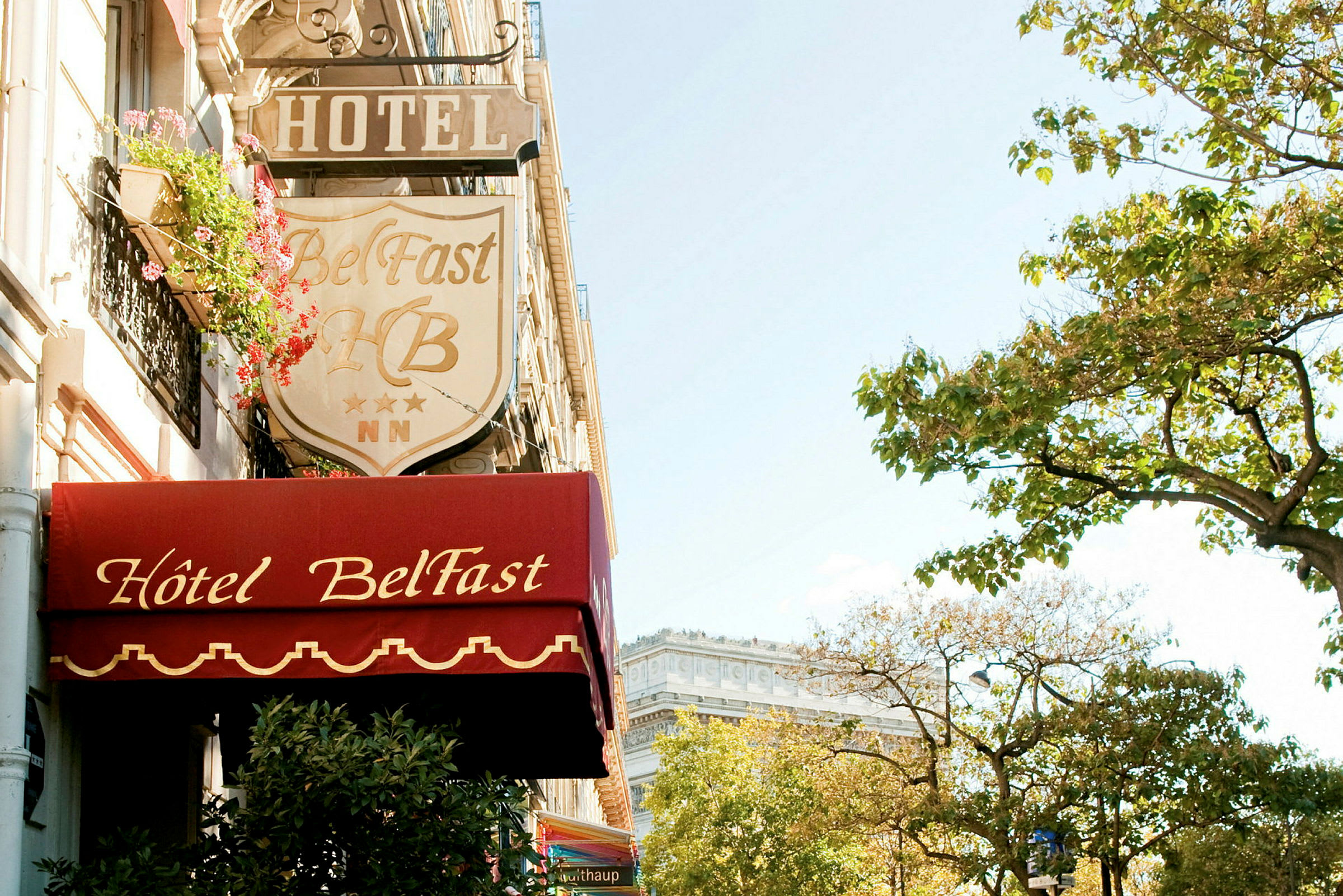 Fasaden til Hotel Belfast med skilt og trær i nærheten. (AI-generert tekst)