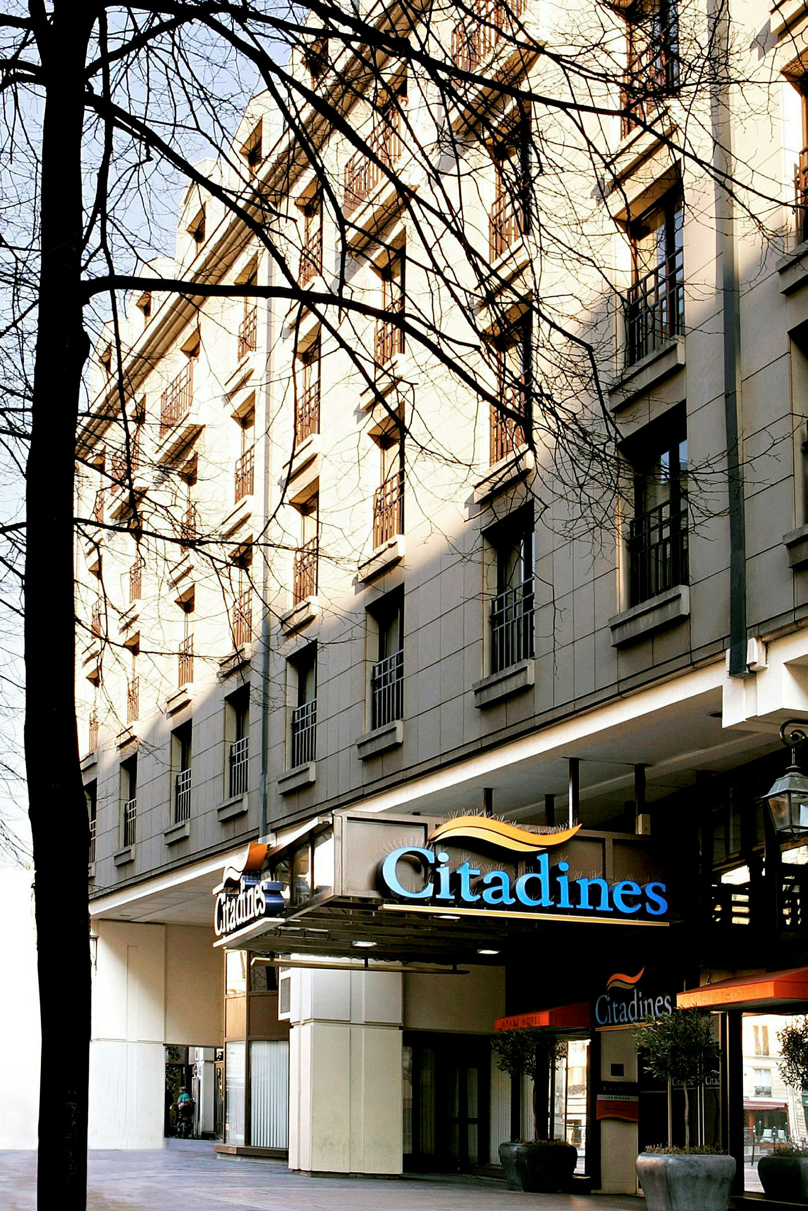 Et fleretasjes hotell med skiltet 'Citadines' ved inngangen. (AI-generert tekst)