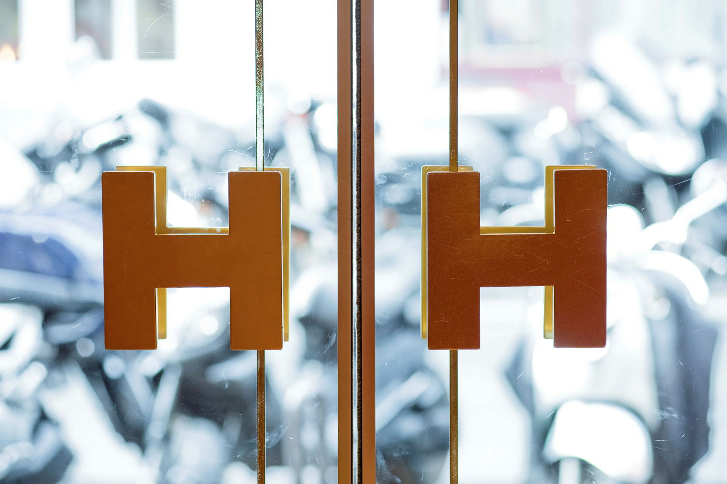 Gjennomsiktige glassdører med H-formede håndtak. (AI-generert tekst)