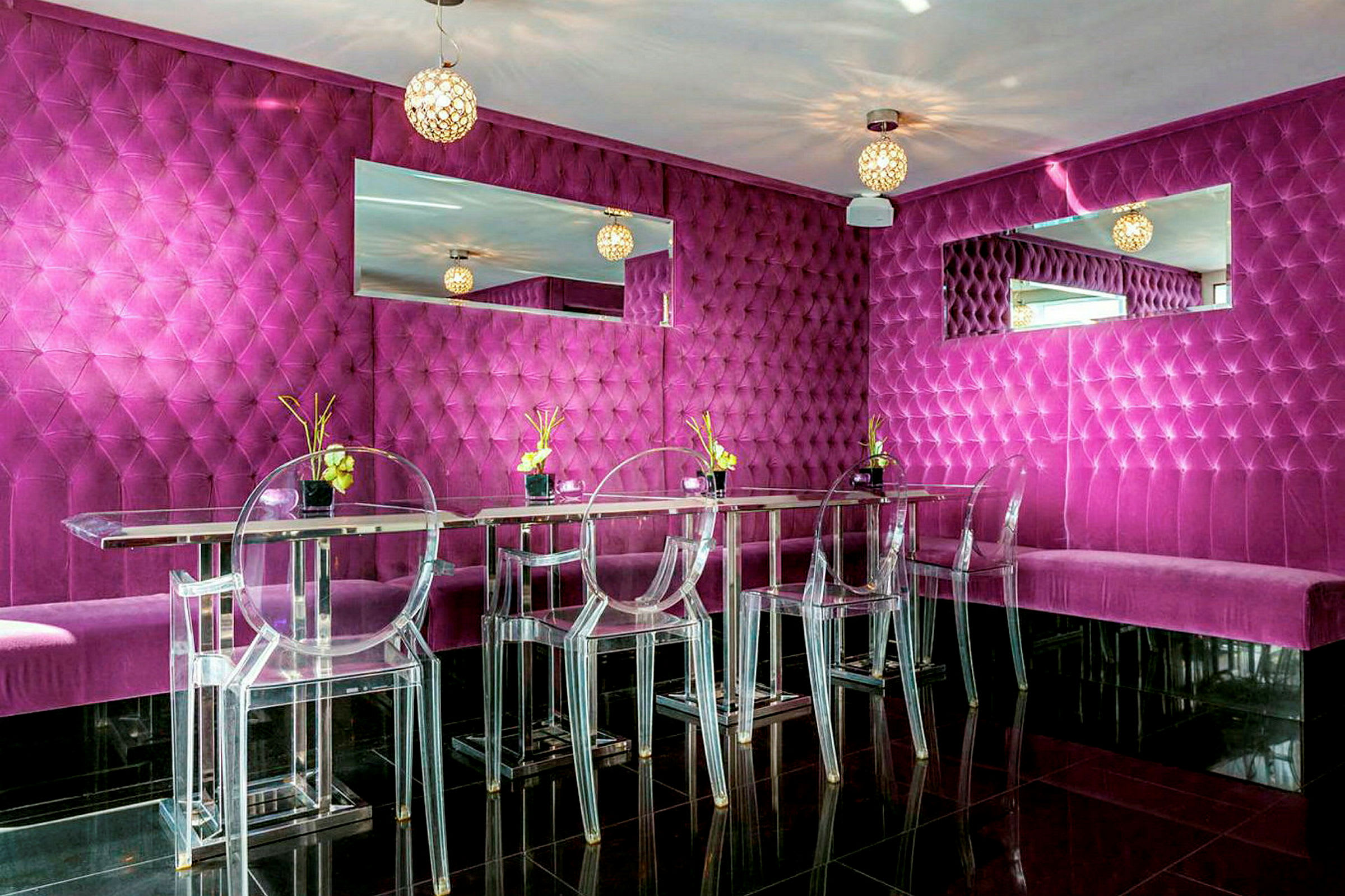 En moderne og fargerik restaurant eller lounge med fuschiafargede veggpaneler, gjennomsiktige stoler og speildekorasjoner. (AI-generert tekst)