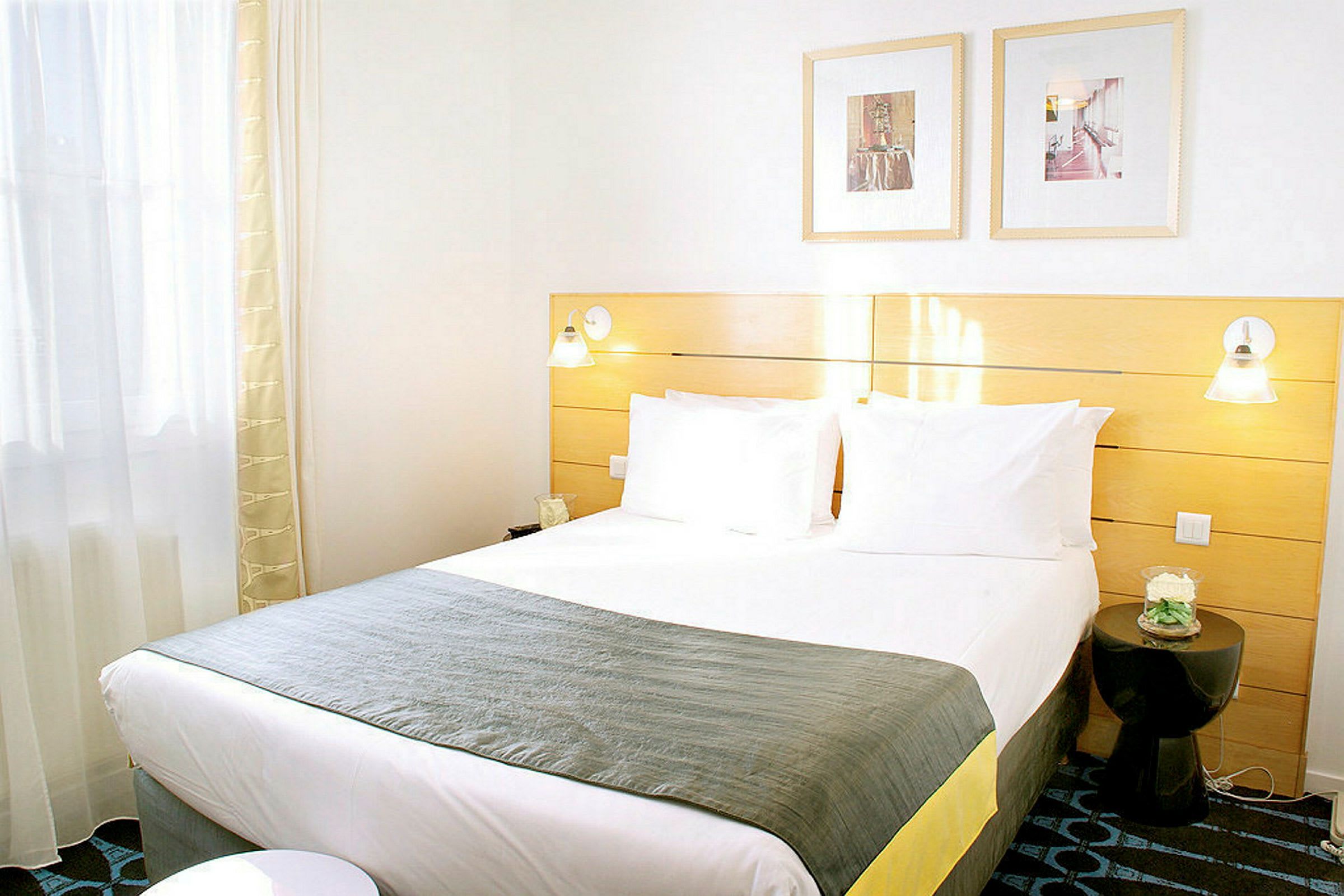 Et lyst hotellrom med en dobbeltseng og moderne innredning. (AI-generert tekst)