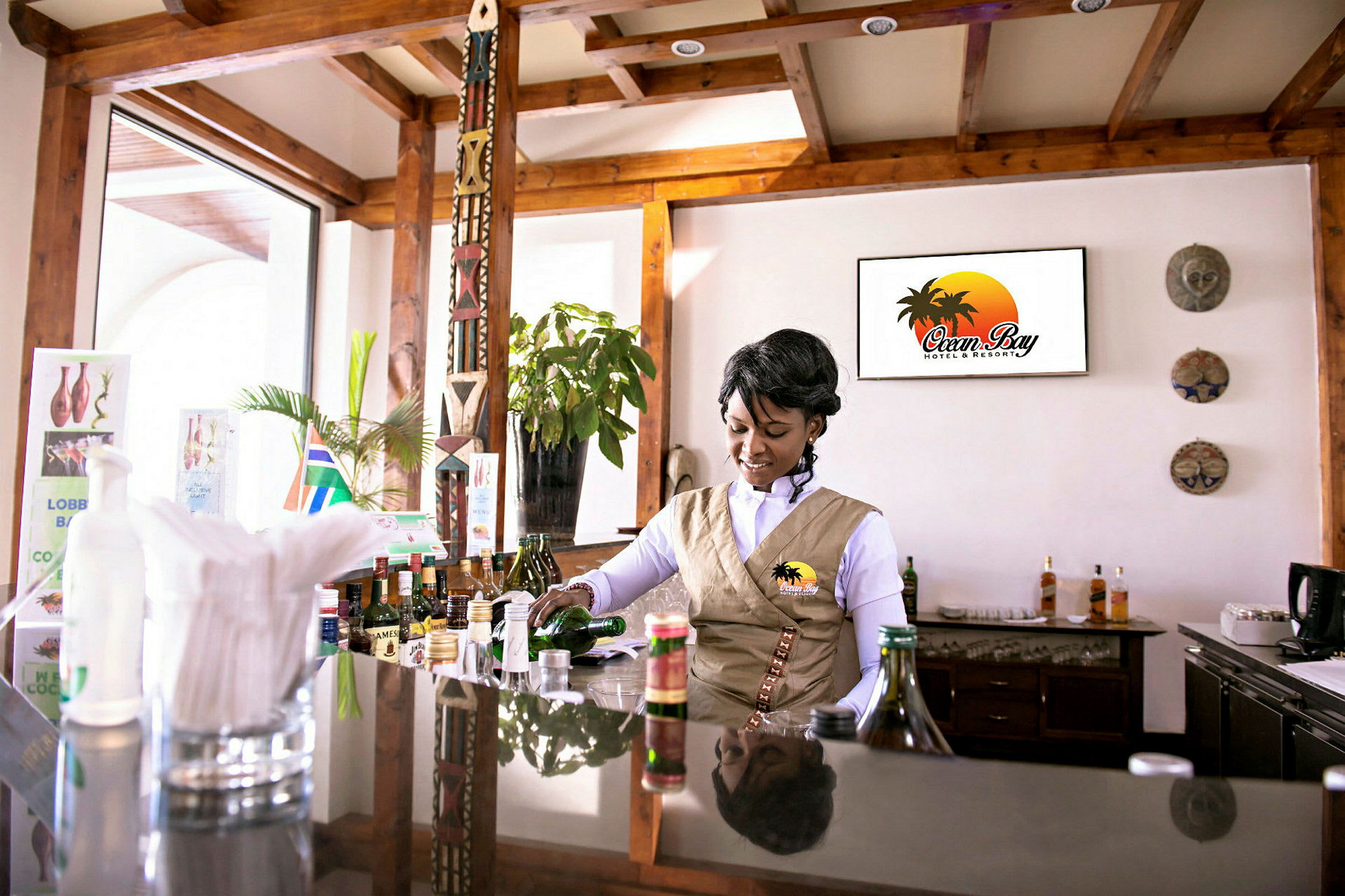 En bartender i uniform forbereder en drink ved en hotellbar. (AI-generert tekst)