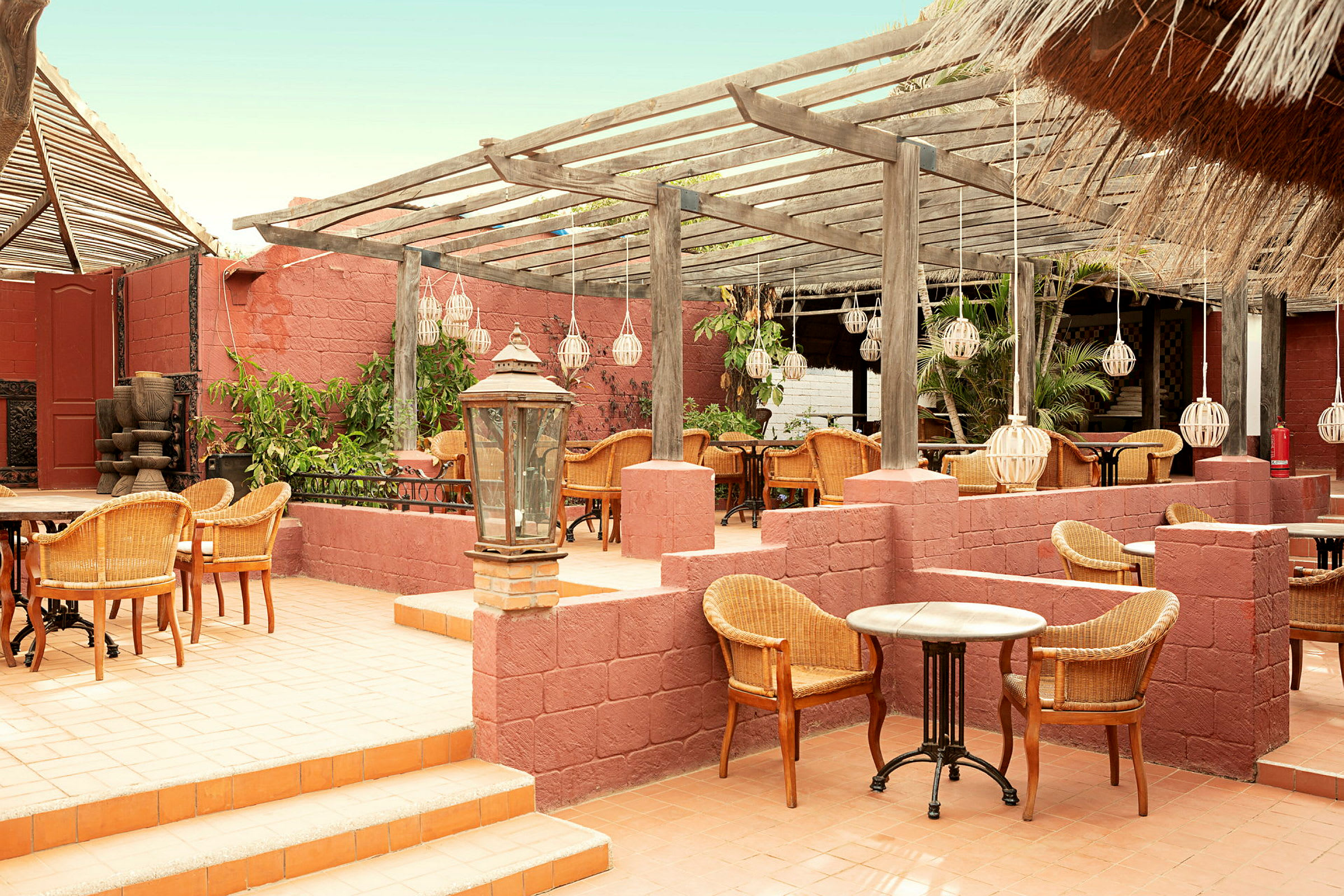 Bilde av en terrasse med rottingmøbler, trepergola og dekorative lykter. (AI-generert tekst)