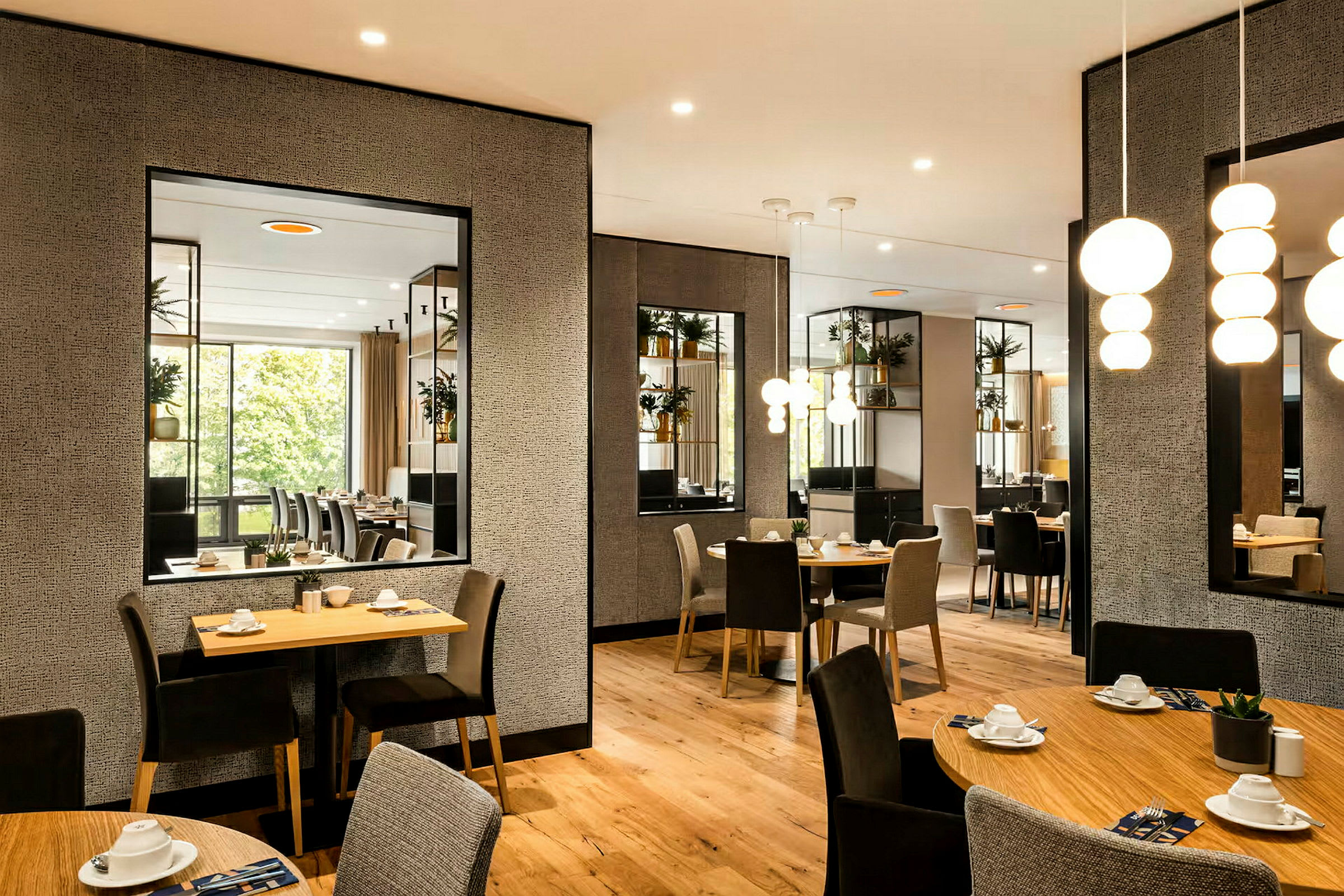 Et godt opplyst kafé eller restaurant med moderne bord og stoler, pynteplanter og speil på veggene. (AI-generert tekst)