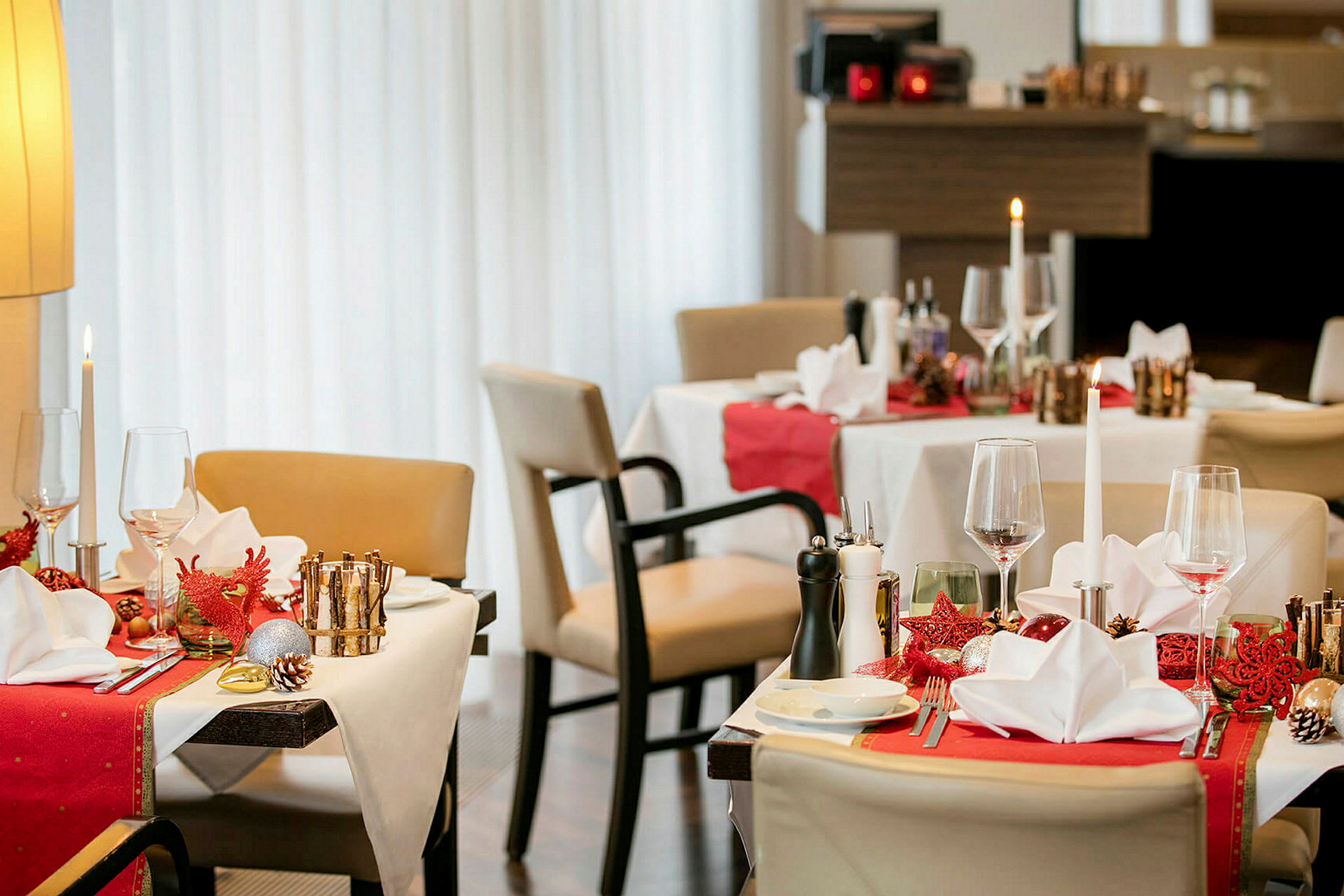 Restaurantbord med juledekorasjoner, dekket med servietter og glass. (AI-generert tekst)