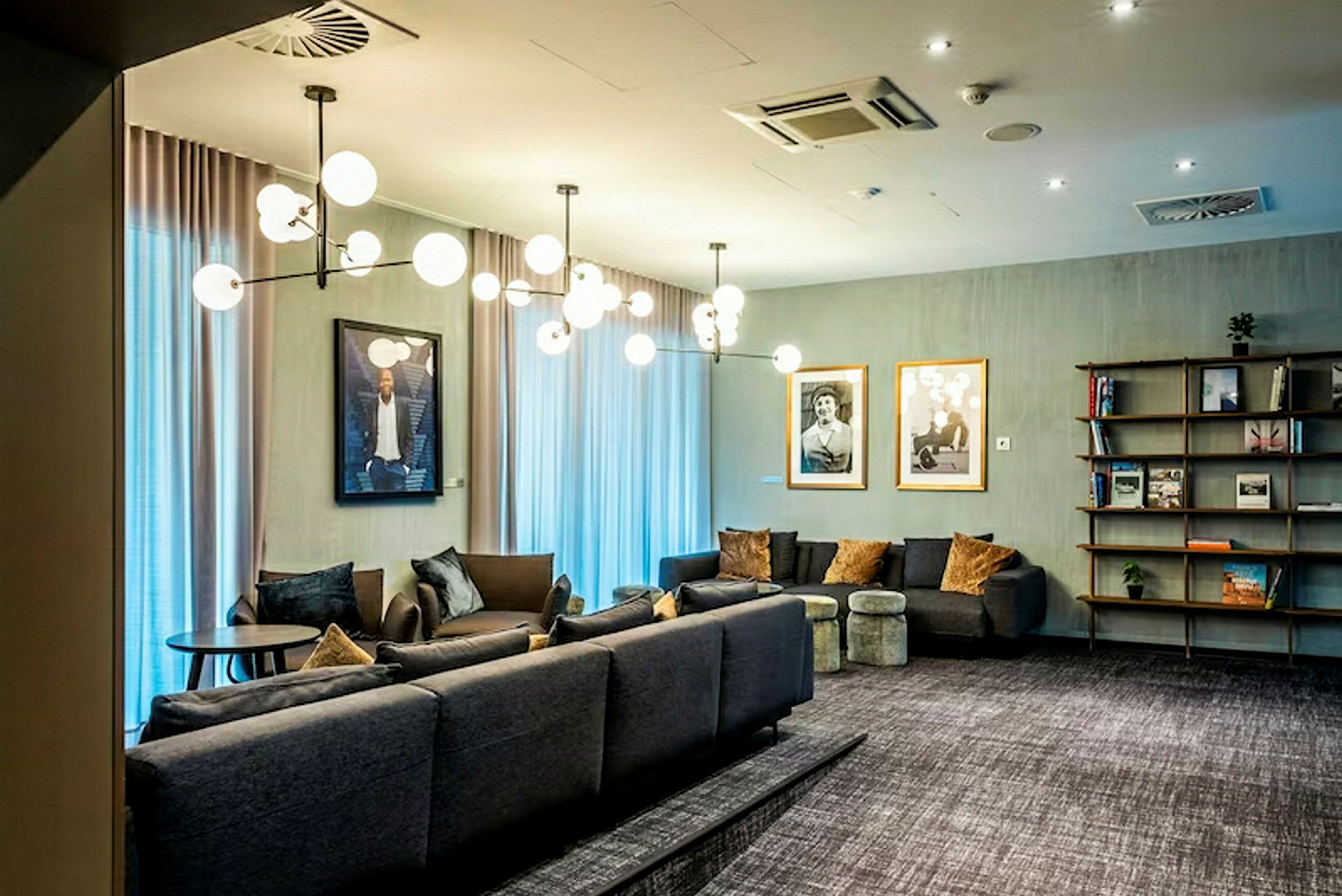 En elegant stue med moderne sofaer, dekorative lys og kunstverk på veggene. (AI-generert tekst)