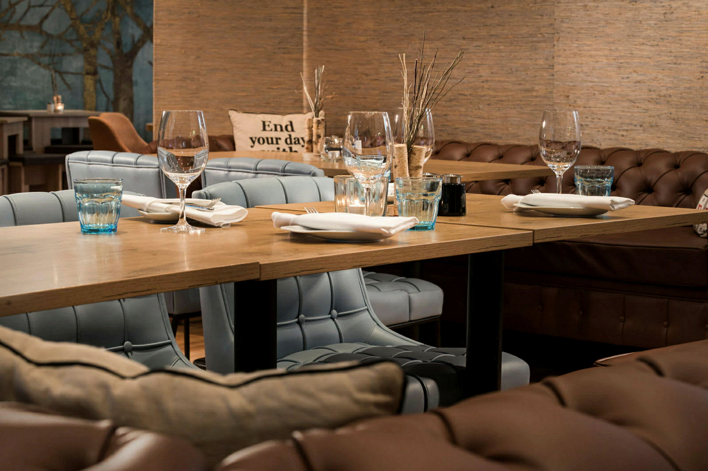 En restaurantinteriør med dekket bord og polstrede stoler. (AI-generert tekst)