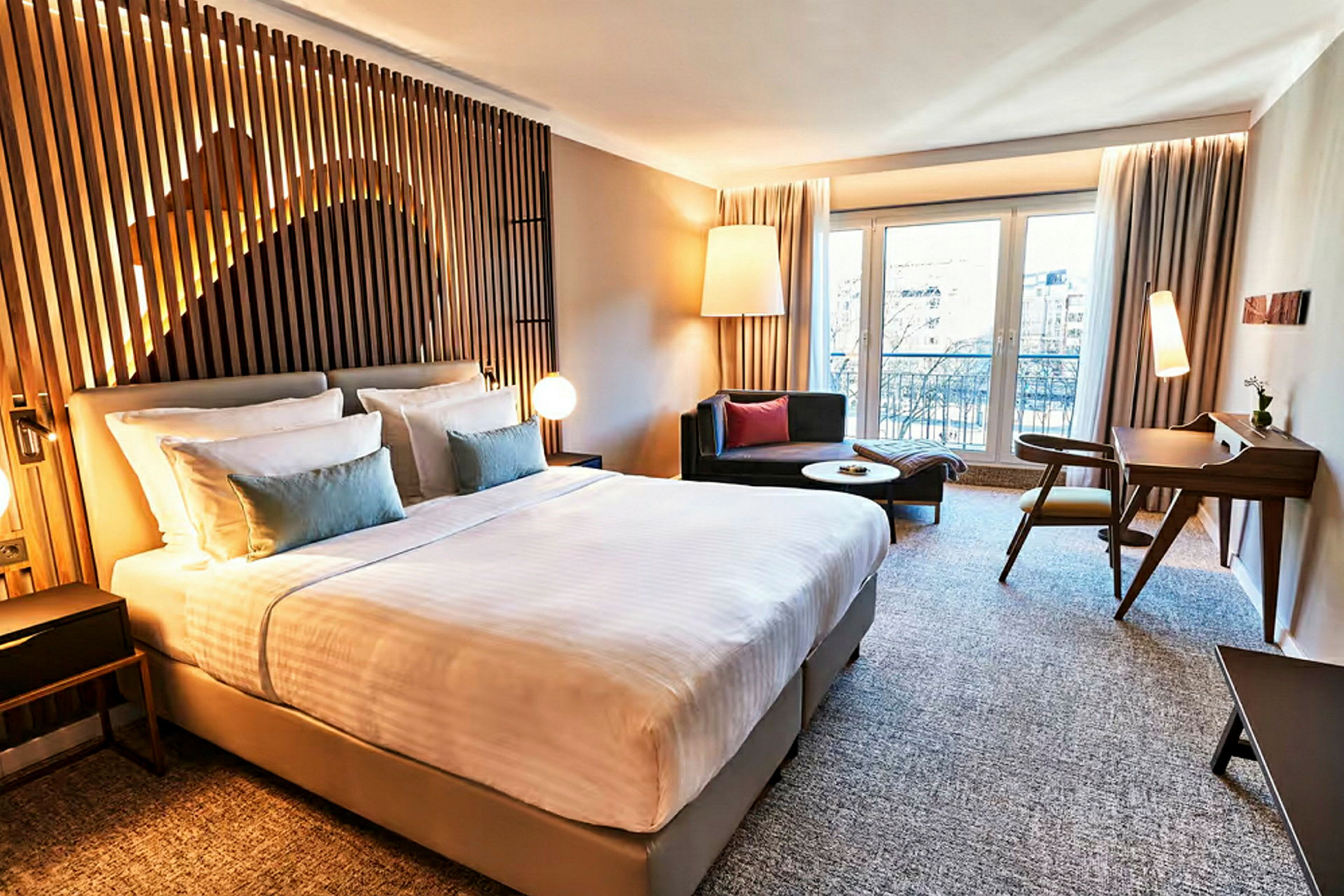 Et moderne hotellrom med en stor seng, sitteplasser og skrivebord. (AI-generert tekst)