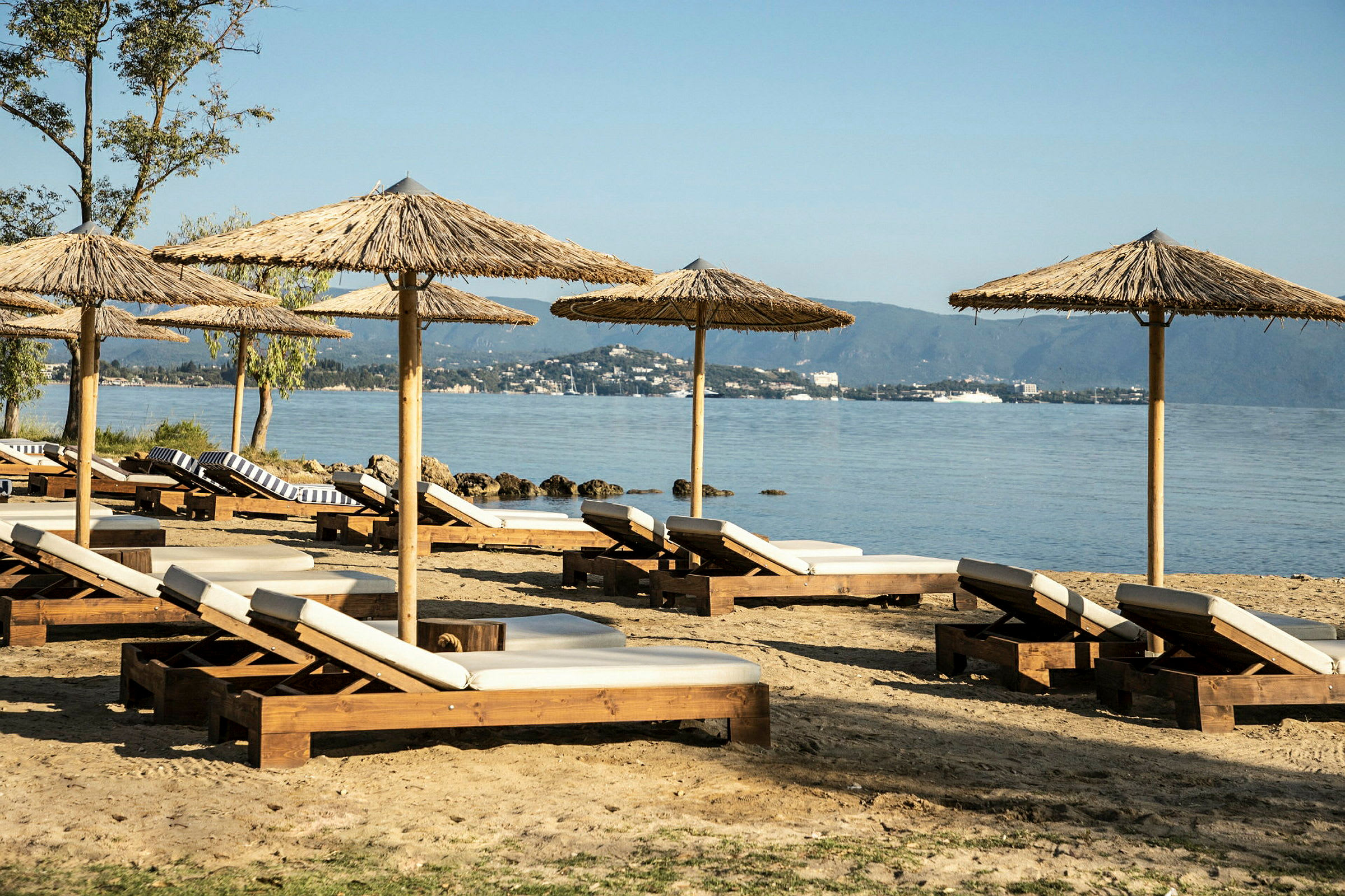 En strand med solsenger og parasoller. (AI-generert tekst)