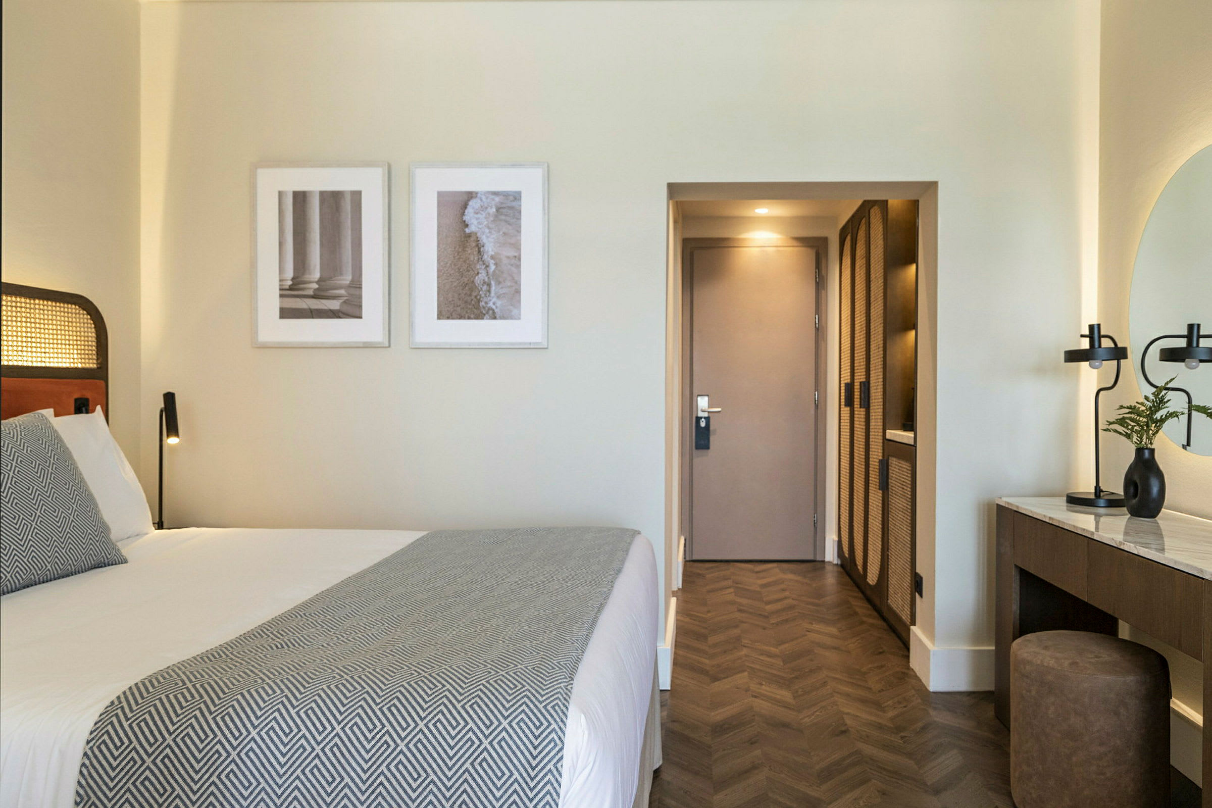 Et velorganisert hotellrom med en dobbeltseng, kunstverk på veggen og en skrivebordsmøbel. (AI-generert tekst)