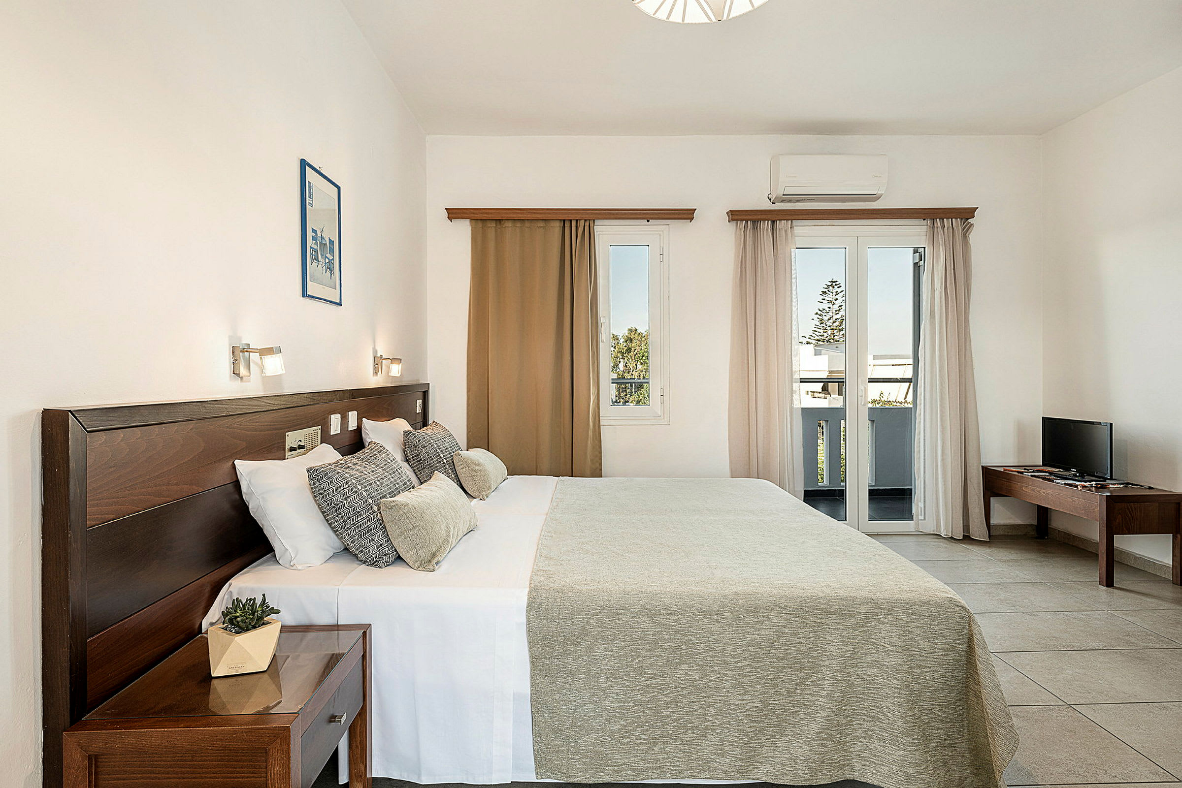 Et hotellrom med dobbeltseng, nattbord, vindu med utsikt og TV på et bord. (AI-generert tekst)