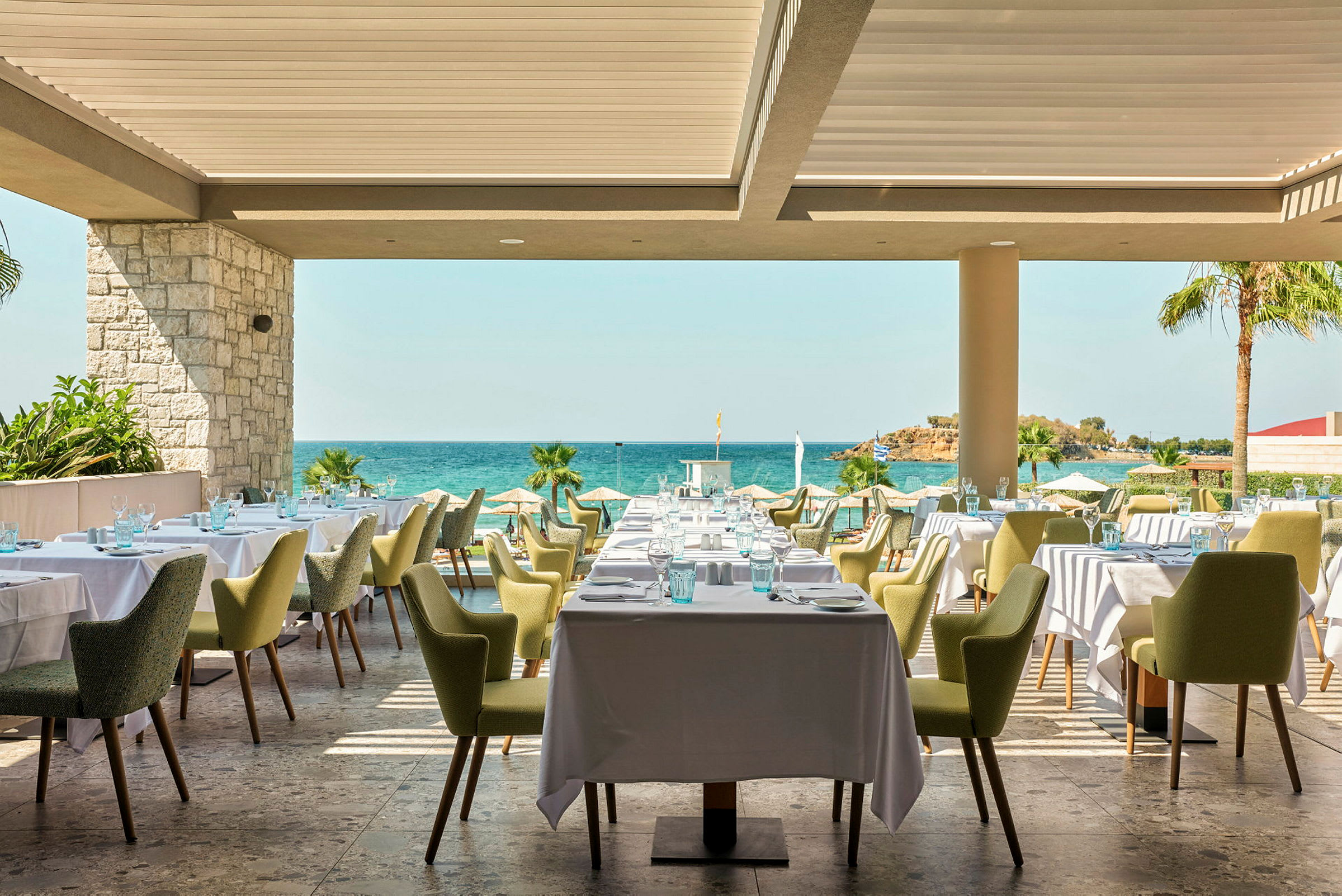 Restaurant med dekkede bord og utsikt mot havet. (AI-generert tekst)