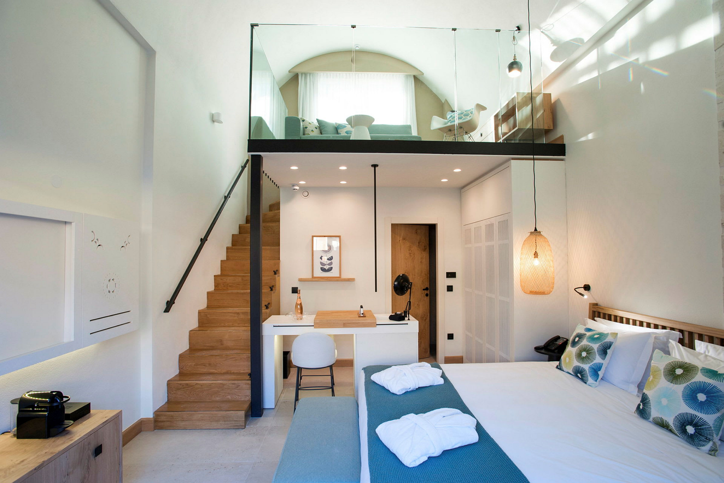 Interiør av et moderne hotellrom med hems, seng, sitteområde og skrivebord. (AI-generert tekst)