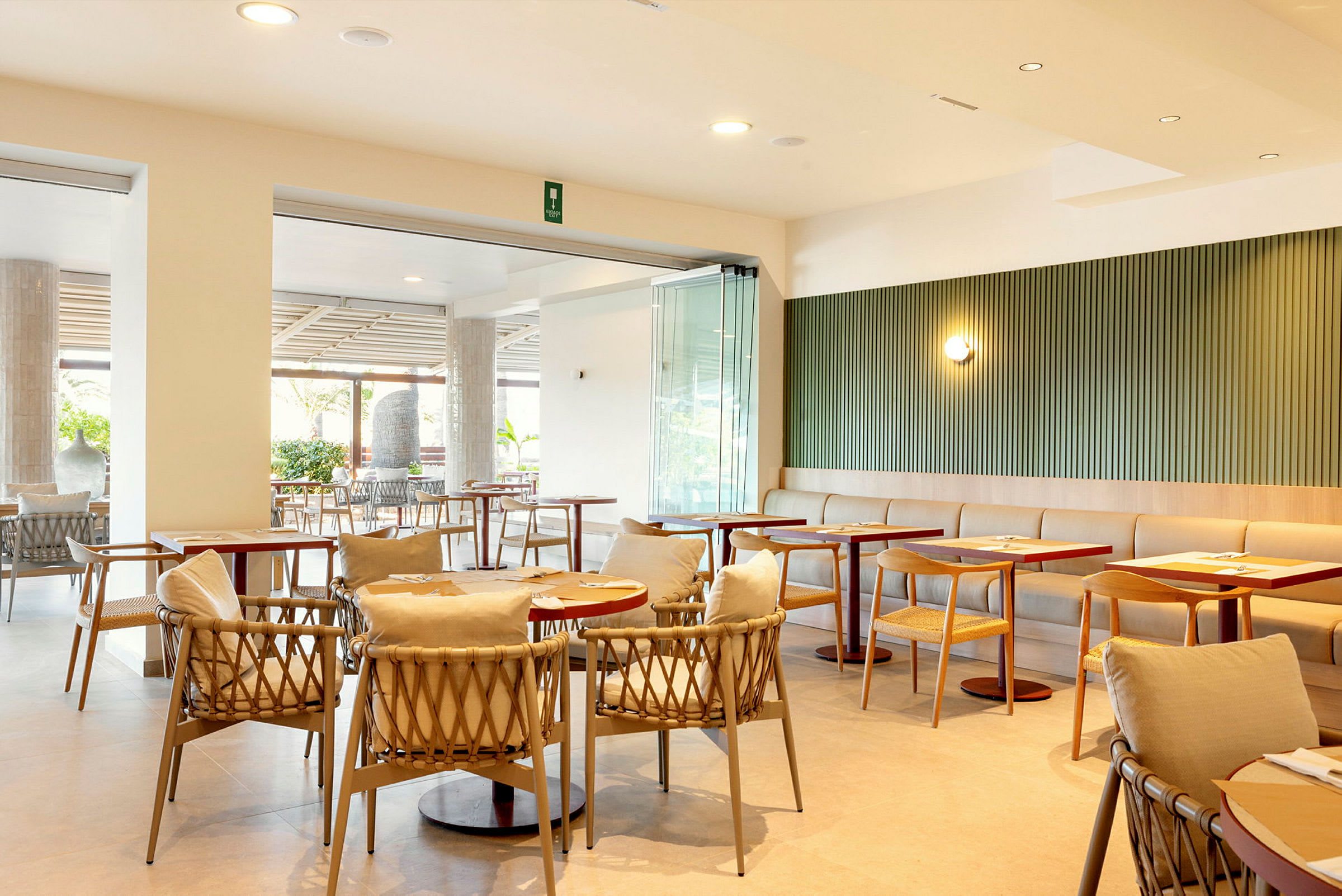 En moderne restaurant med bord og stoler samt lyse interiørdetaljer. (AI-generert tekst)