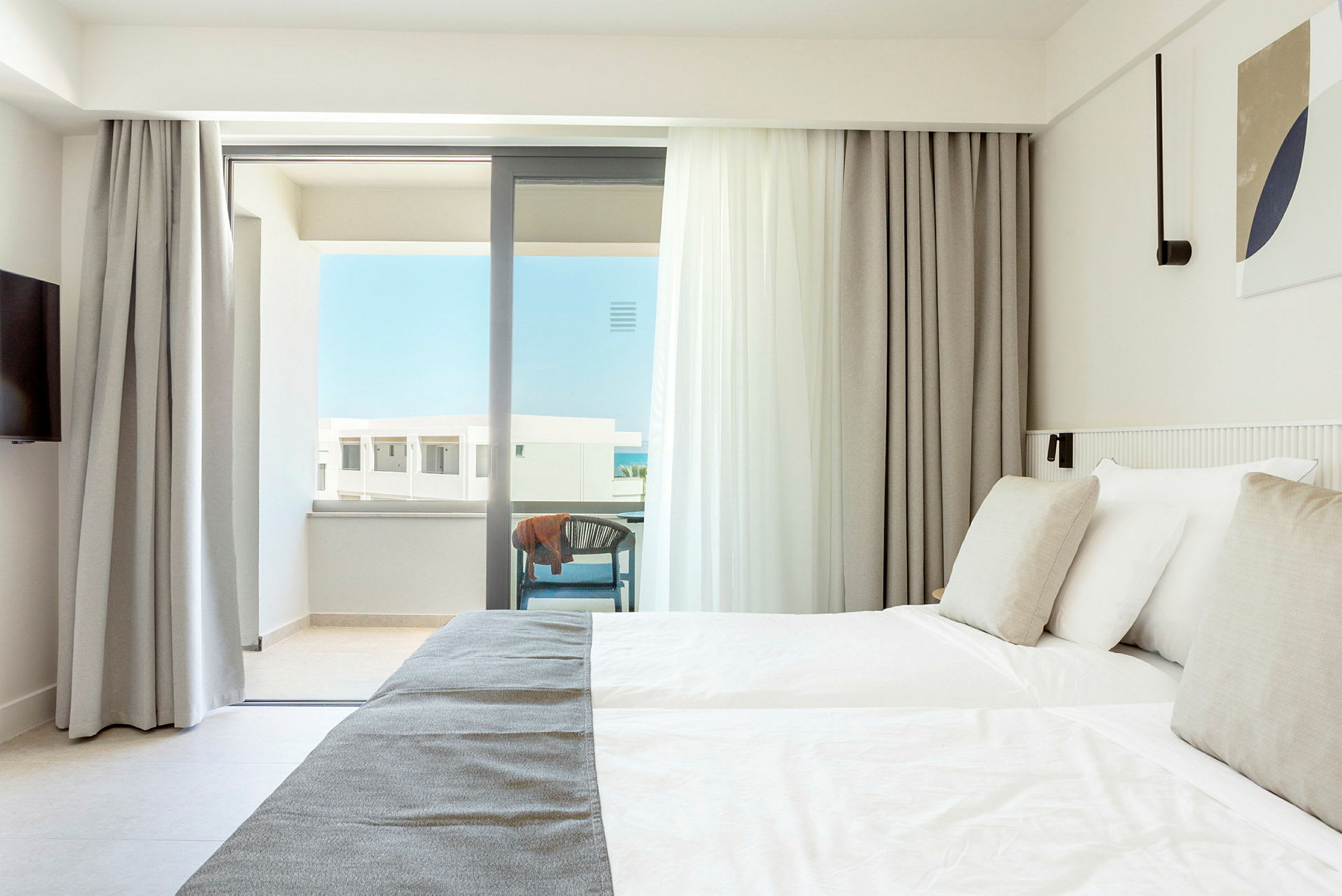 Lyst hotellrom med dobbeltseng og balkong. (AI-generert tekst)