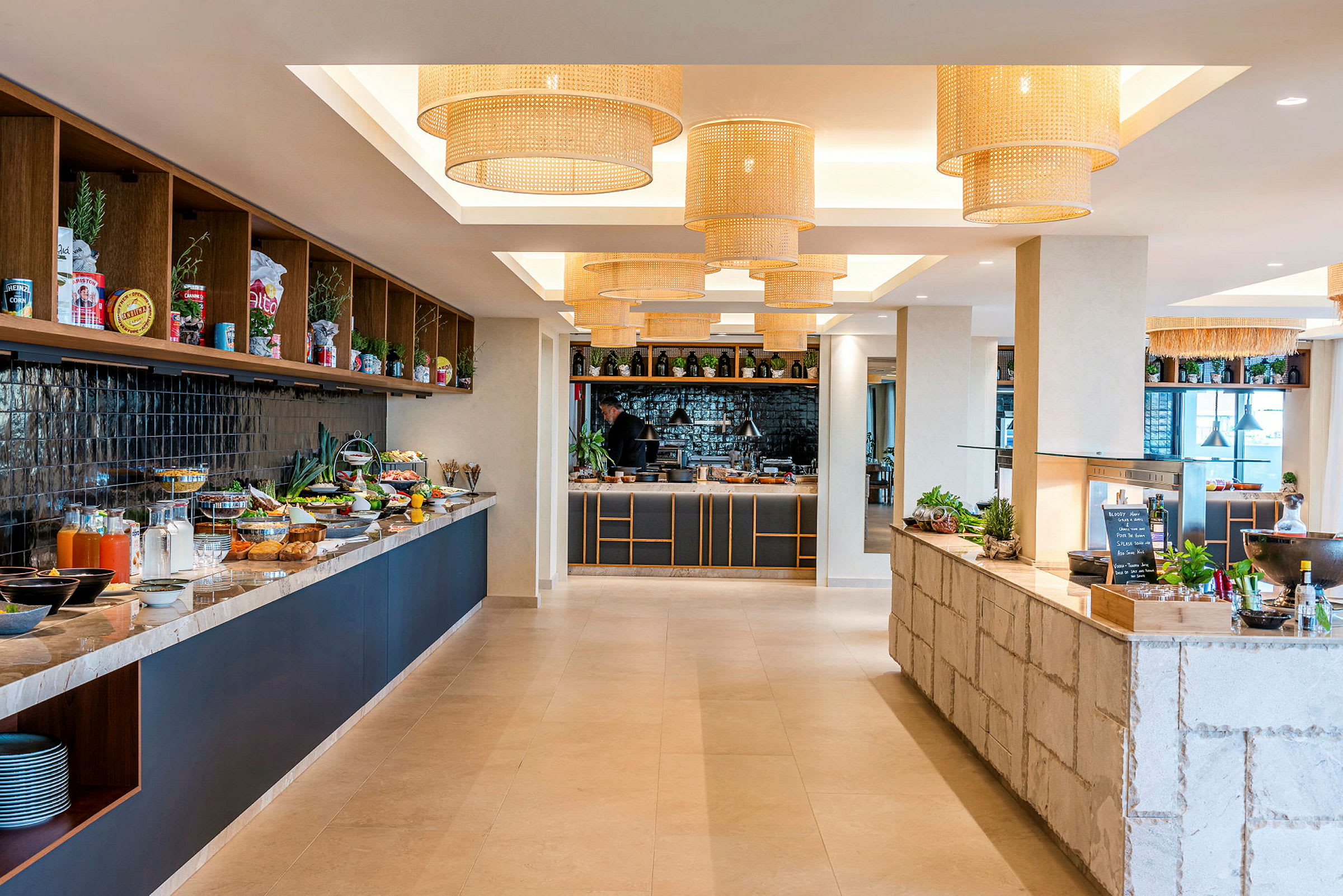 Bilde av en moderne buffetrestaurant med mat og drikke plassert på benker og dekorative taklamper. (AI-generert tekst)